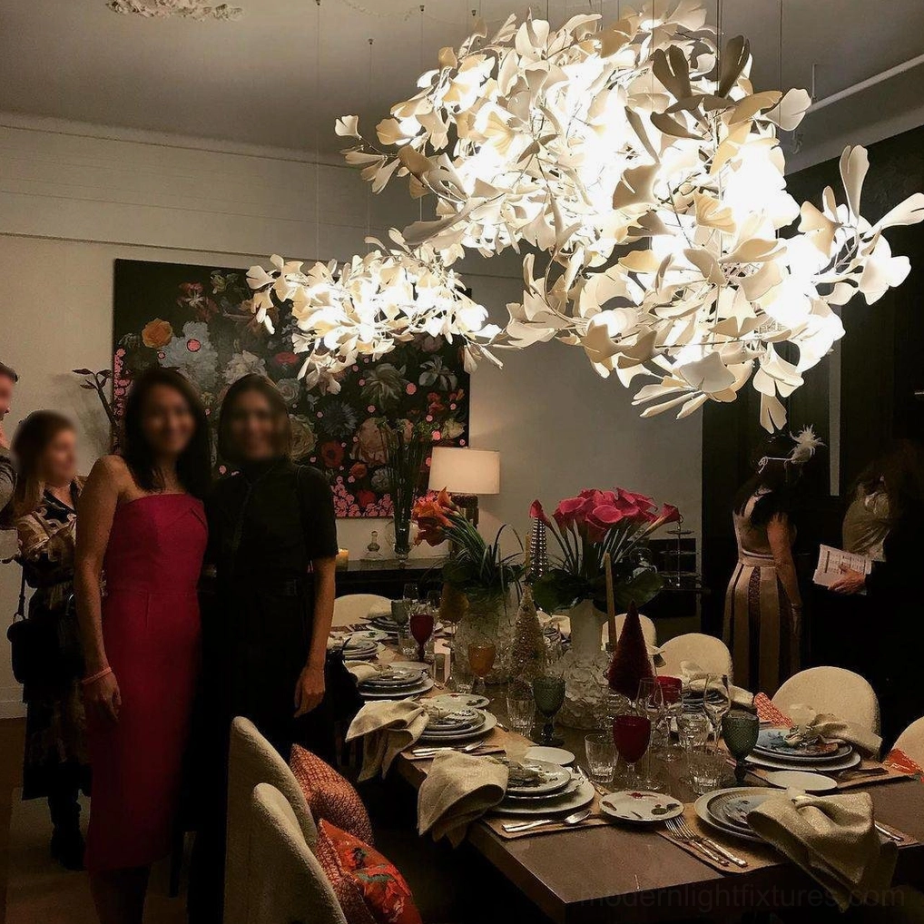 Contemporary ginkgo leaf pendant chandelier creating focal point above dining table in luxury residence