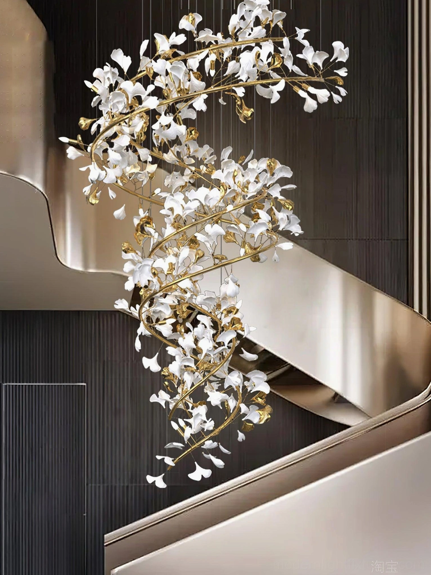 Ginkgo leaf crystal chandelier with gold metal branches positioned beside grey metal modern staircase with dark paneled walls