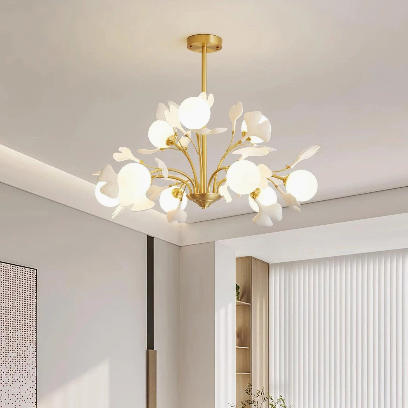 Ginkgo chandelier installed in modern minimalist living room, eye-level view with warm brass finish and glowing frosted shades