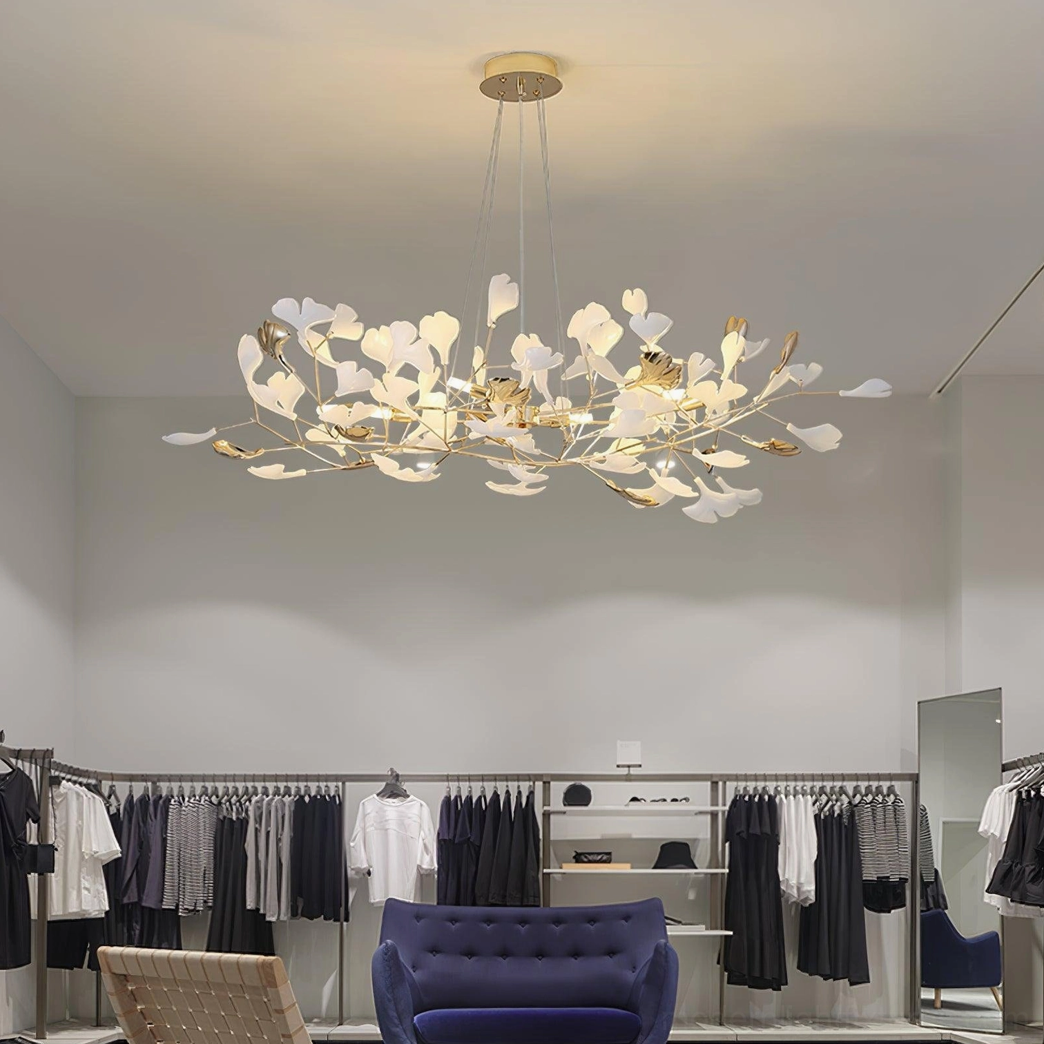 Ginkgo leaf pendant chandelier installed in luxury retail boutique with warm illuminated lighting and contemporary ambiance