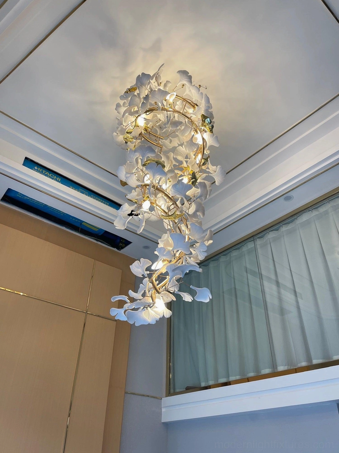 Side profile of ginkgo leaf chandelier featuring spiral arrangement of ceramic leaves and metal branch framework