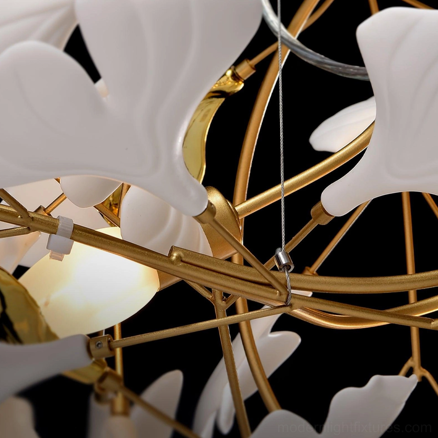Modern ginkgo leaf chandelier lighting - warm illumination from ceramic pendant fixture in elegant interior space