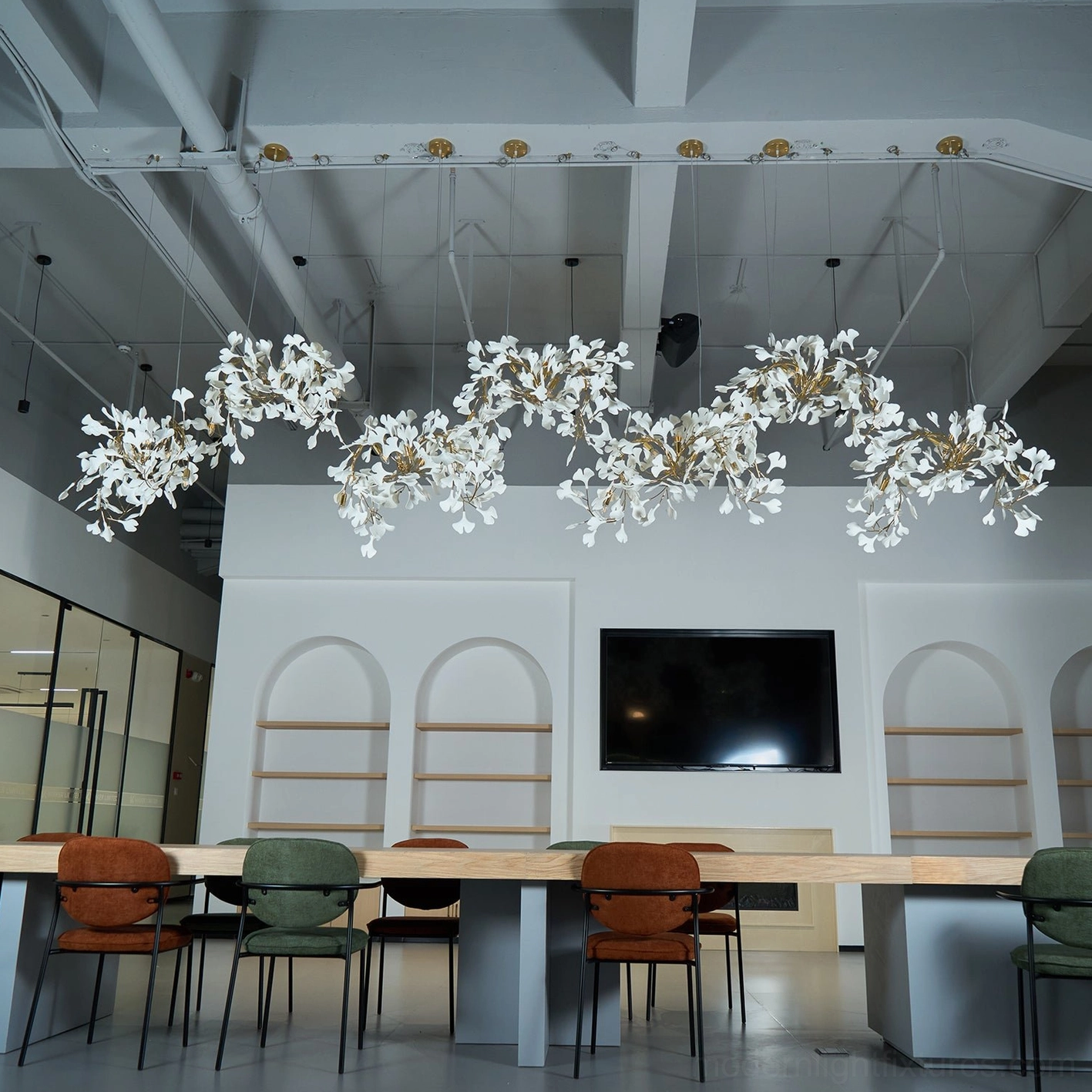 Ginkgo leaf pendant chandelier with pure white ceramic leaves and bright cool illumination in modern office space