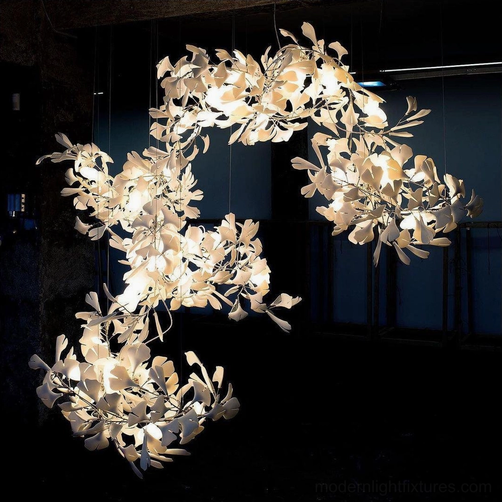 Close-up detail of ginkgo leaf chandelier showing bright warm white light through clustered ceramic leaves