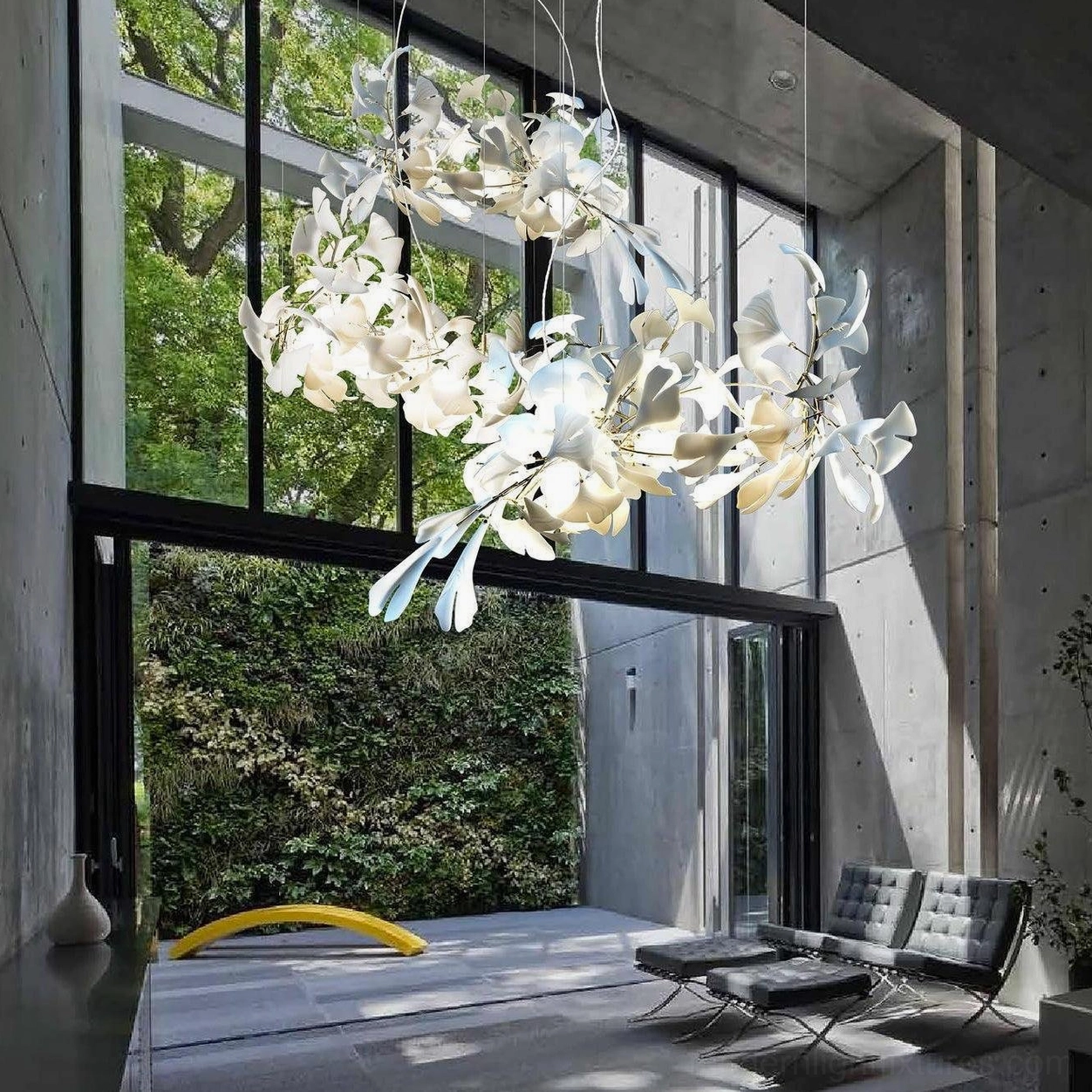 Ginkgo leaf chandelier in modern concrete villa living room with natural daylight and garden views