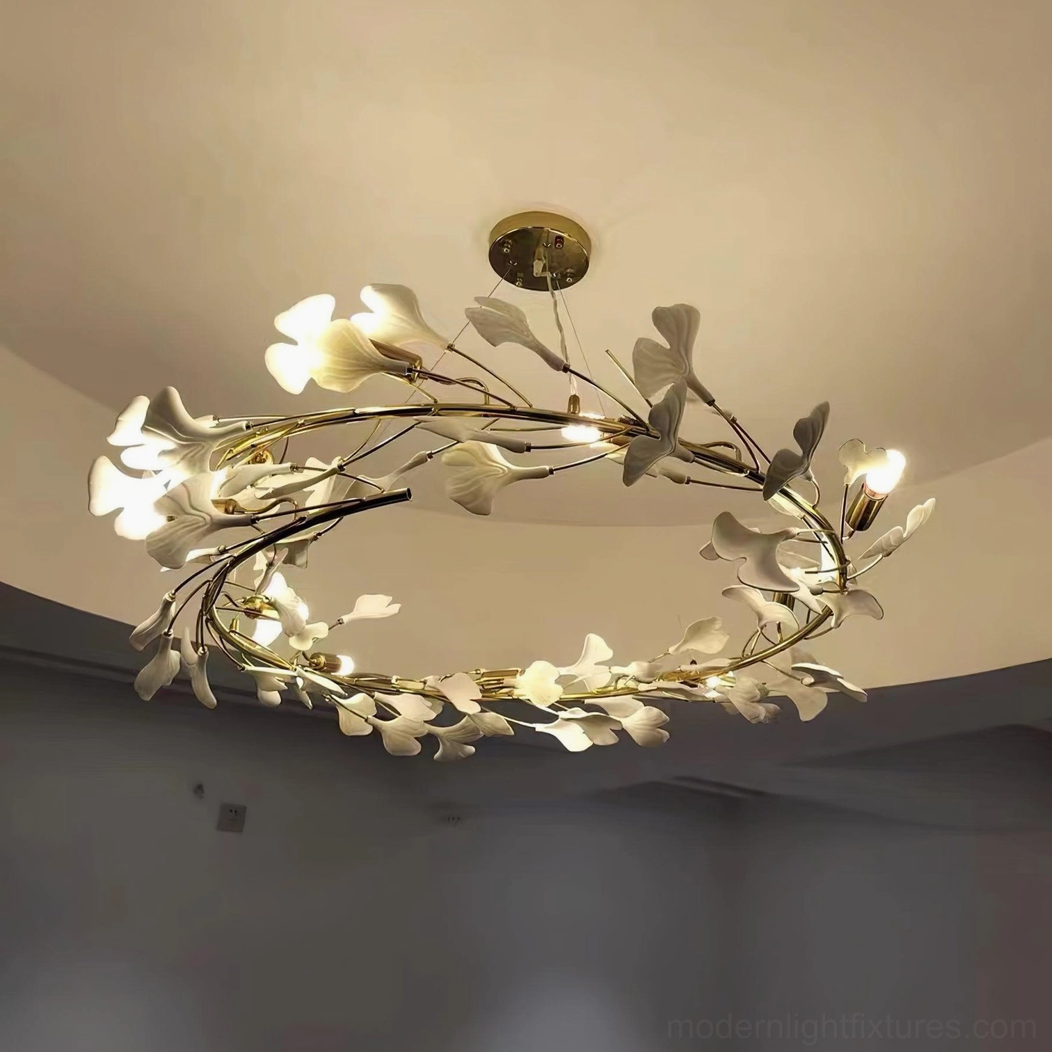 Modern ginkgo leaf chandelier hanging in contemporary home with sculptural white leaves