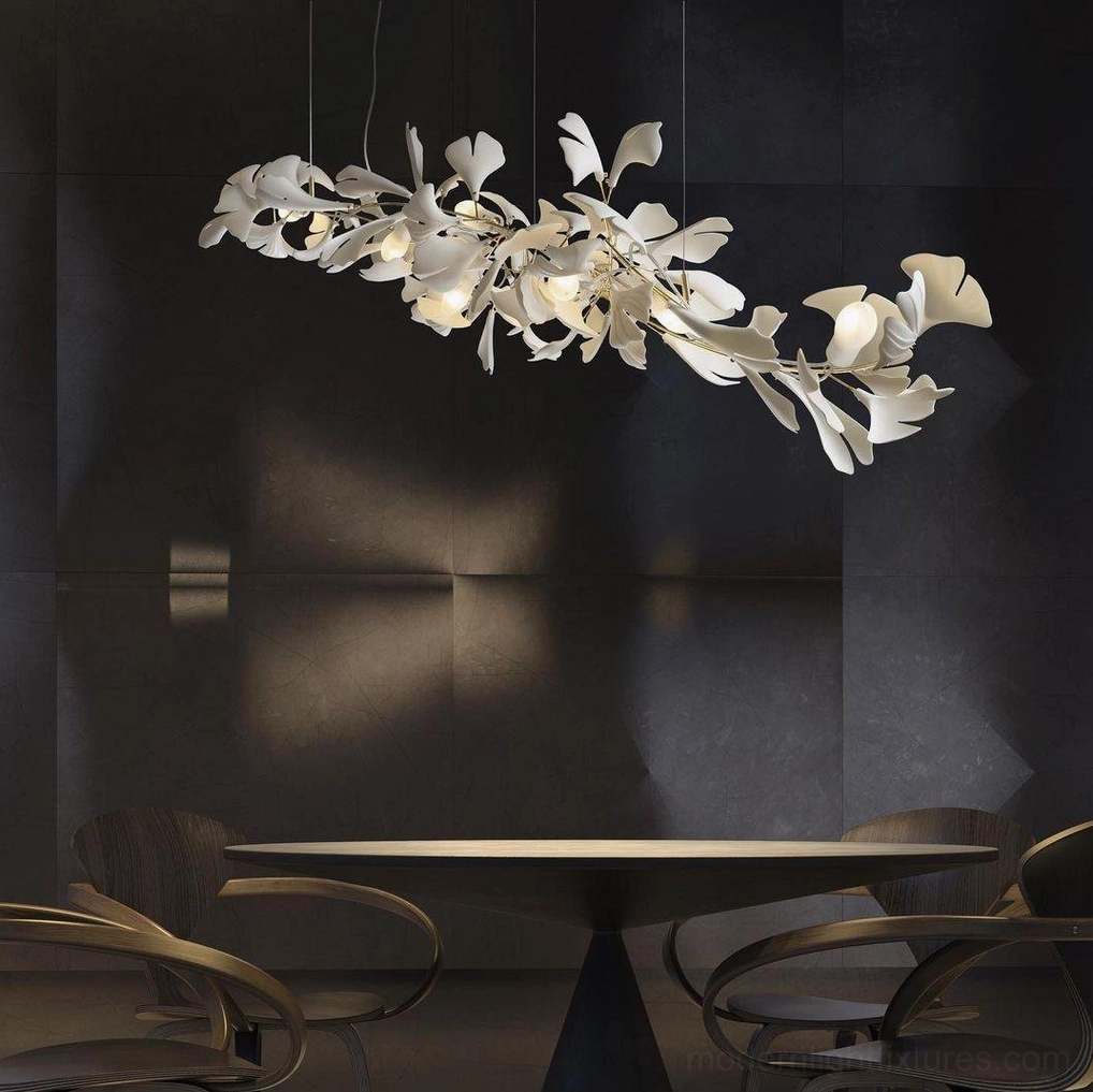 Linear ginkgo leaf chandelier eye-level view in modern formal dining room with off-white ceramic leaf shades and warm interior lighting dark ambiance