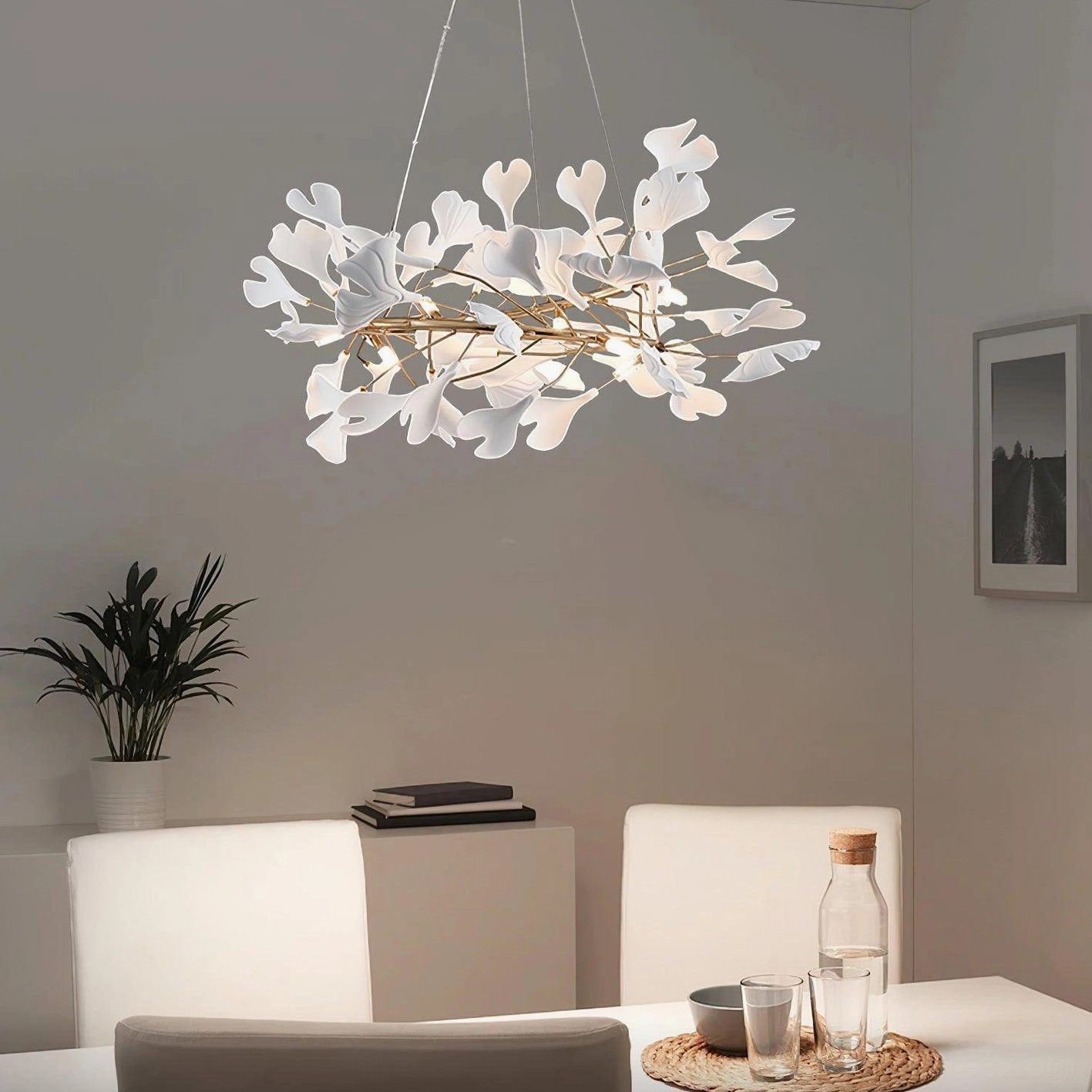 Modern ginkgo leaf pendant light in luxury dining room setting with gold frame and white ceramic accents