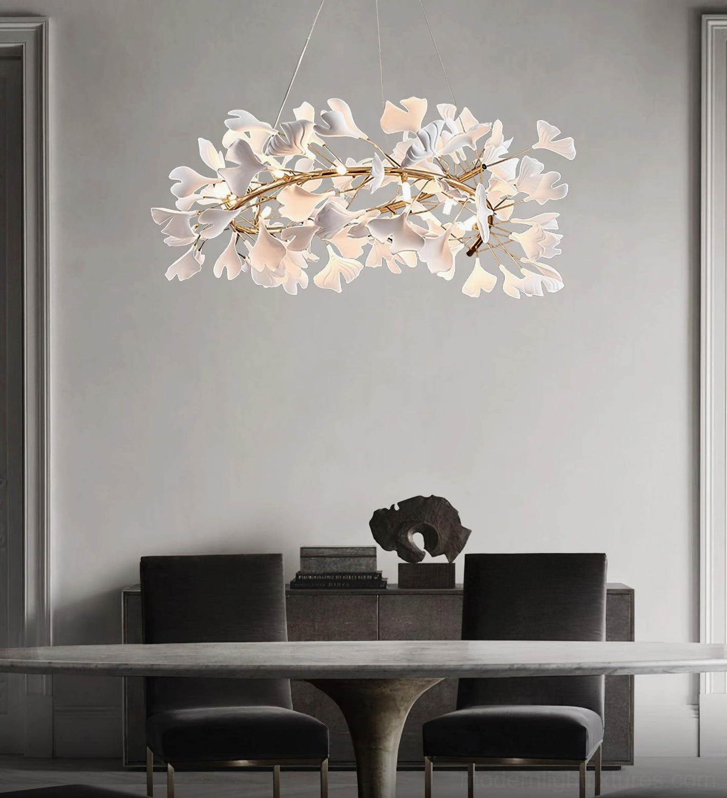 Ginkgo leaf chandelier above formal dining room with black chairs and gold frame