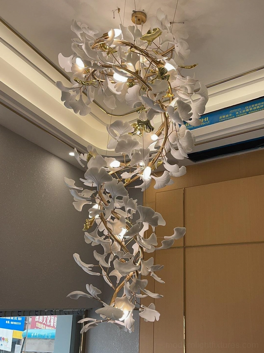 Ginkgo leaf chandelier with metallic frame suspended in high-ceiling contemporary home displaying botanical design inspiration