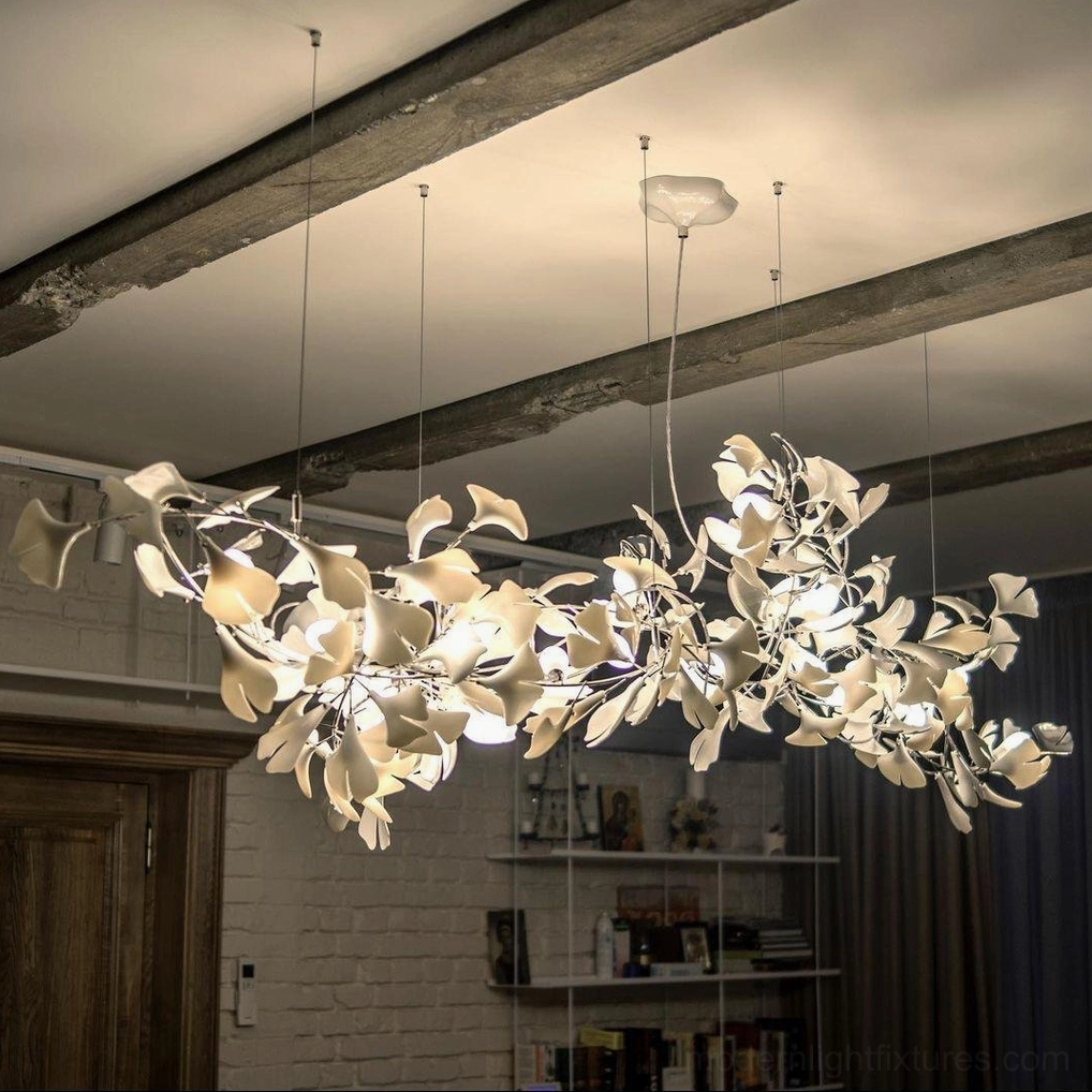 Ginkgo leaf chandelier installed in indoor home interior with warm ambient lighting, exposed wooden ceiling beams, mixed gold and cream leaf accents
