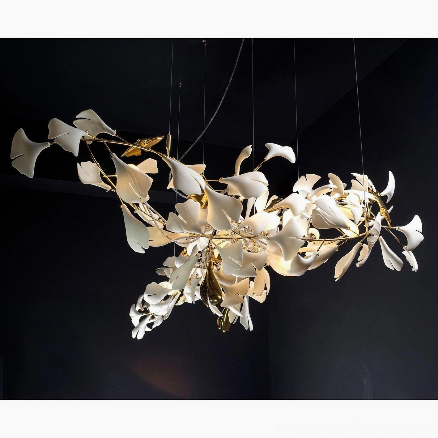 Ginkgo leaf chandelier low angle view featuring polished gold branches and matte white ceramic leaves