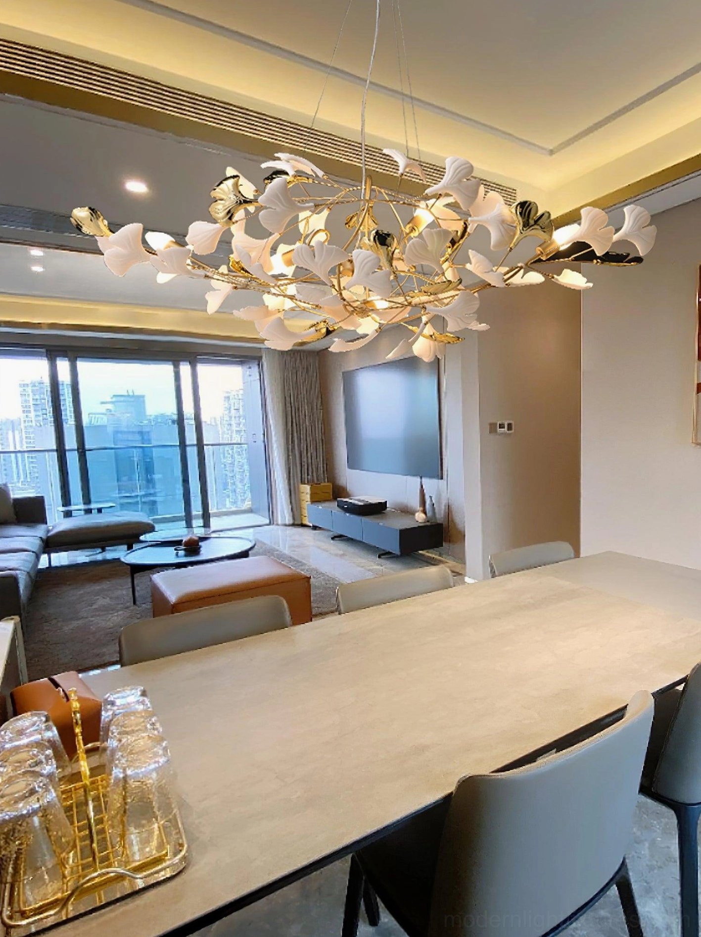 Ginkgo leaf modern chandelier in dining room - overhead view above long table with large windows and warm ambient lighting