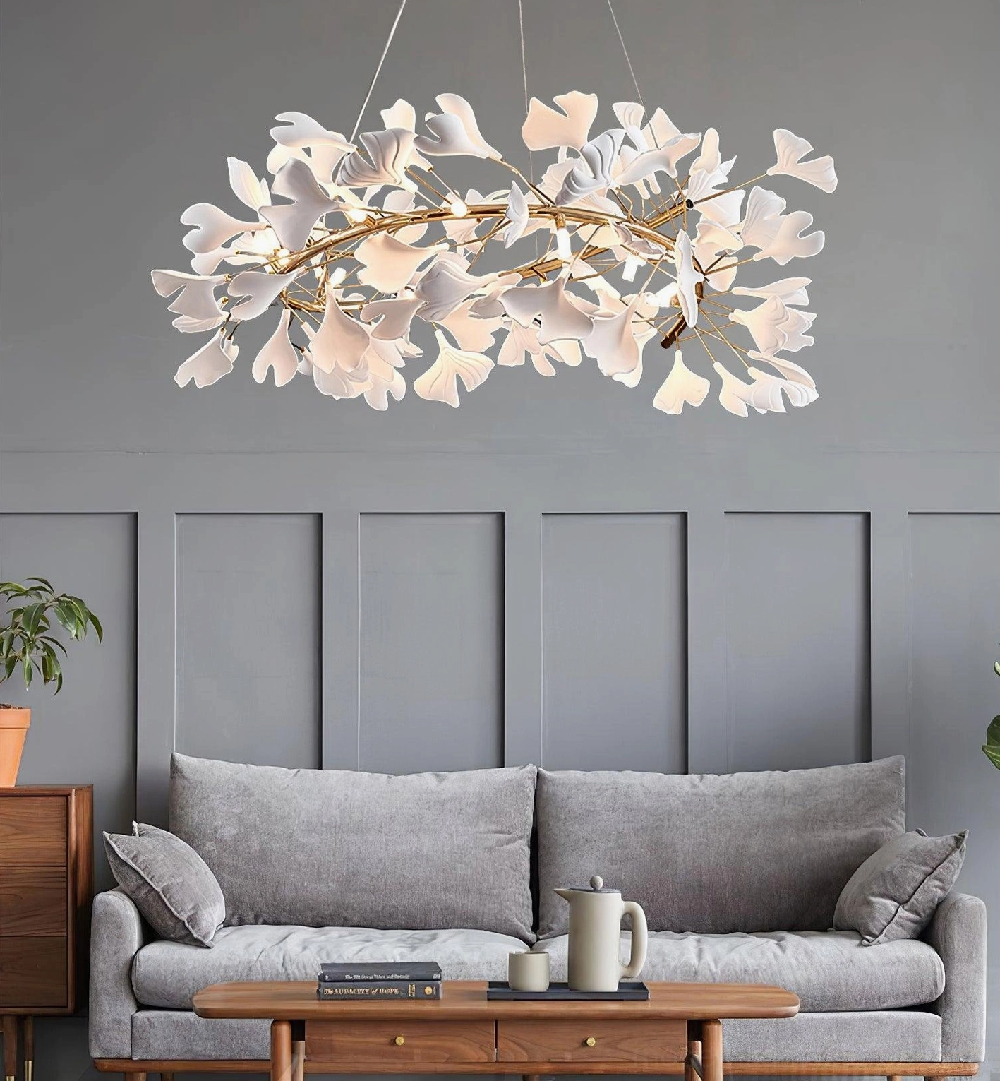Contemporary ginkgo leaf chandelier with clustered white ceramic leaves above modern living room sofa