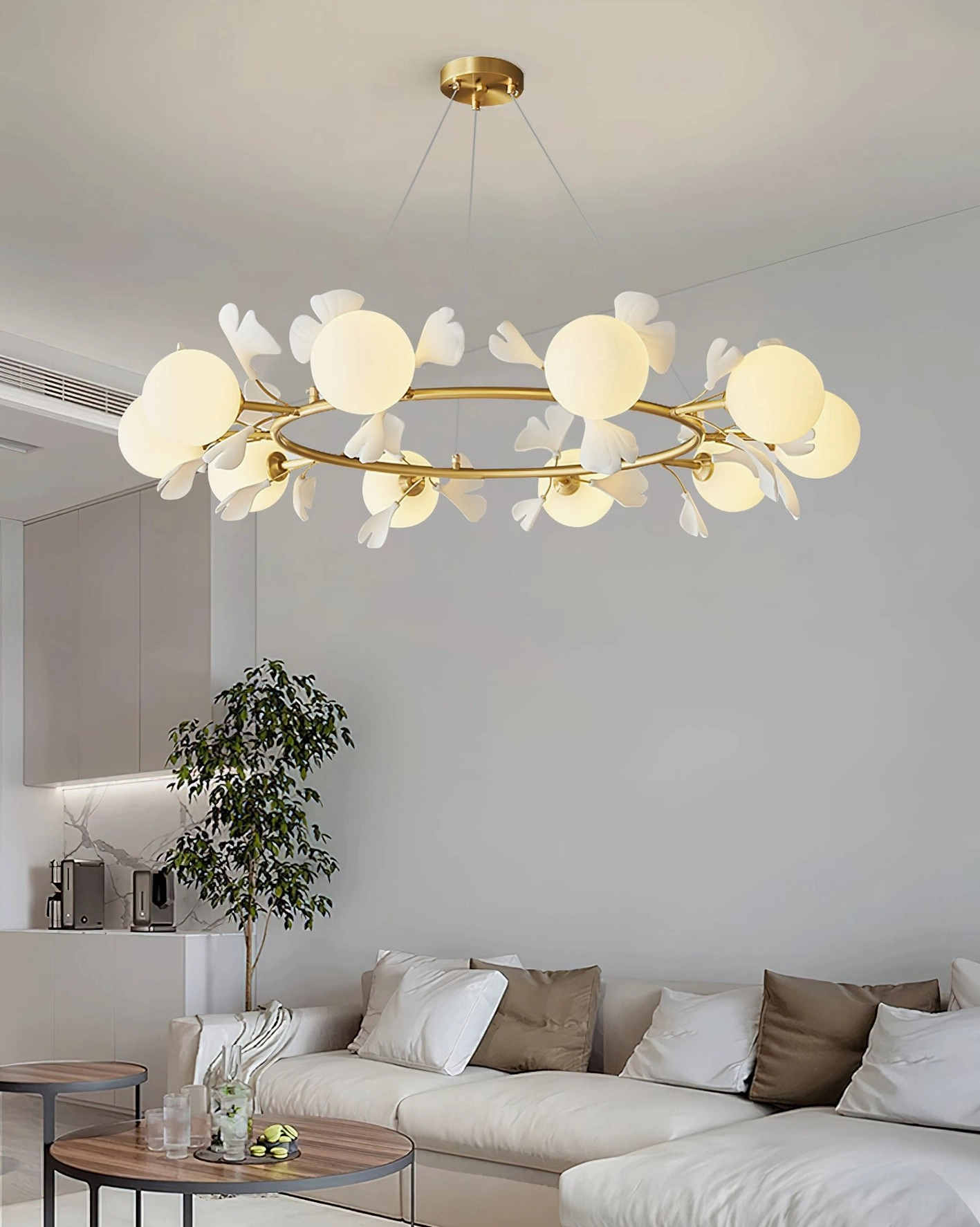Ginkgo leaf brass chandelier installed in modern living room with ambient lighting