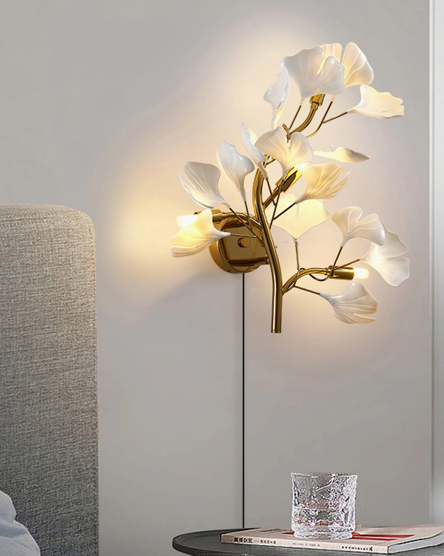 Modern ginkgo leaf wall sconce illuminating bedroom side table scene with neutral grey decor and ambient glow