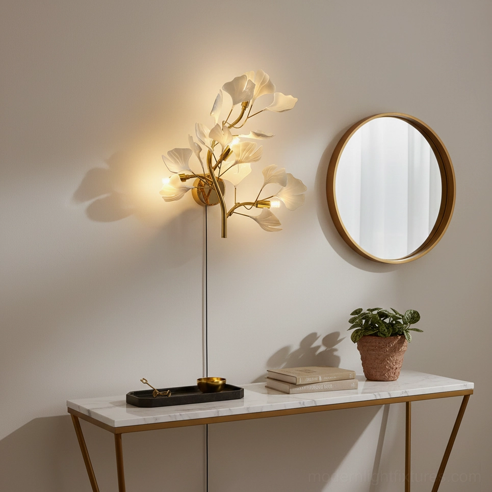 Gold ginkgo leaf wall sconce in modern foyer with round mirror and marble console table decor