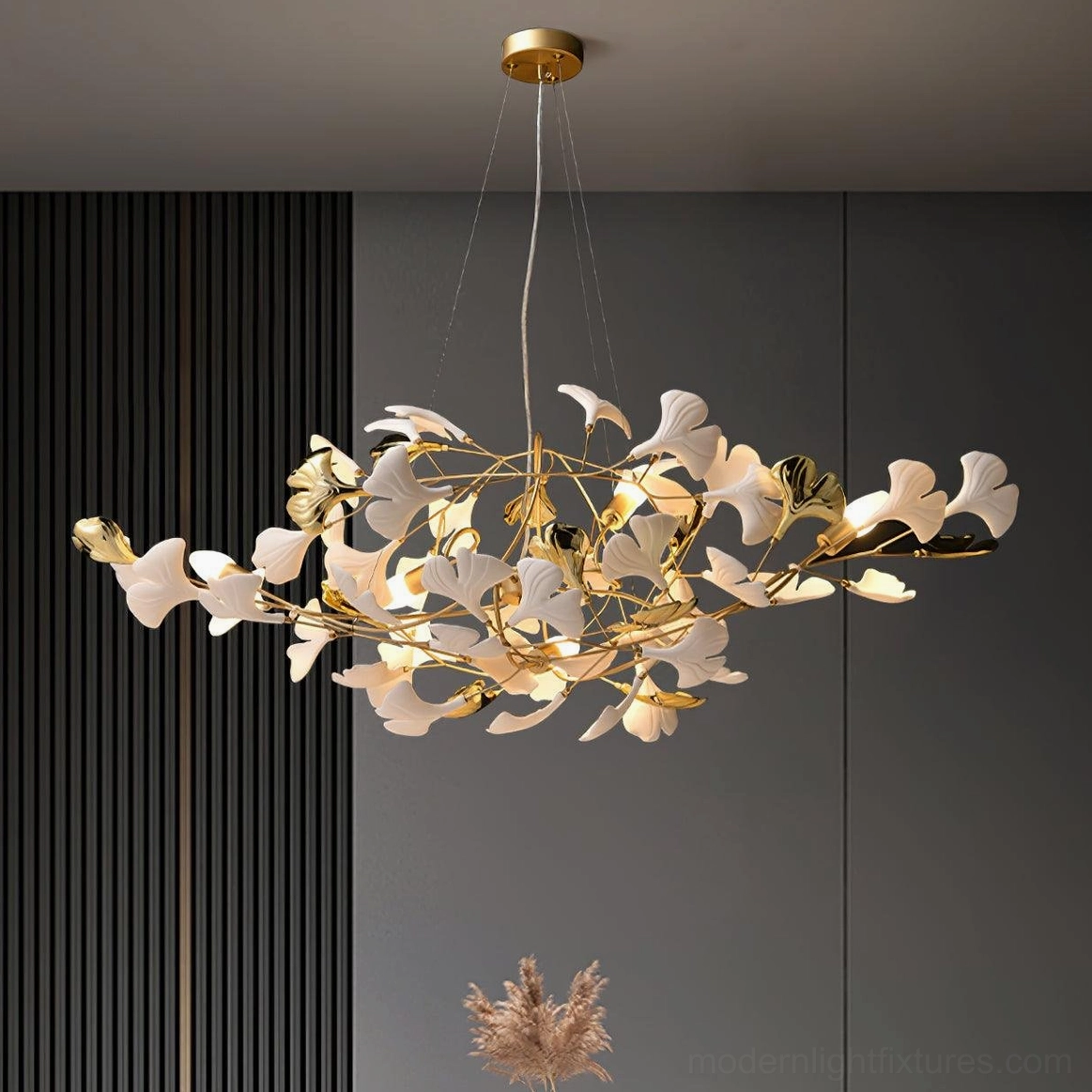 Ginkgo leaf pendant chandelier in living room overhead view - gold metal with white ceramic leaves in dark luxury interior