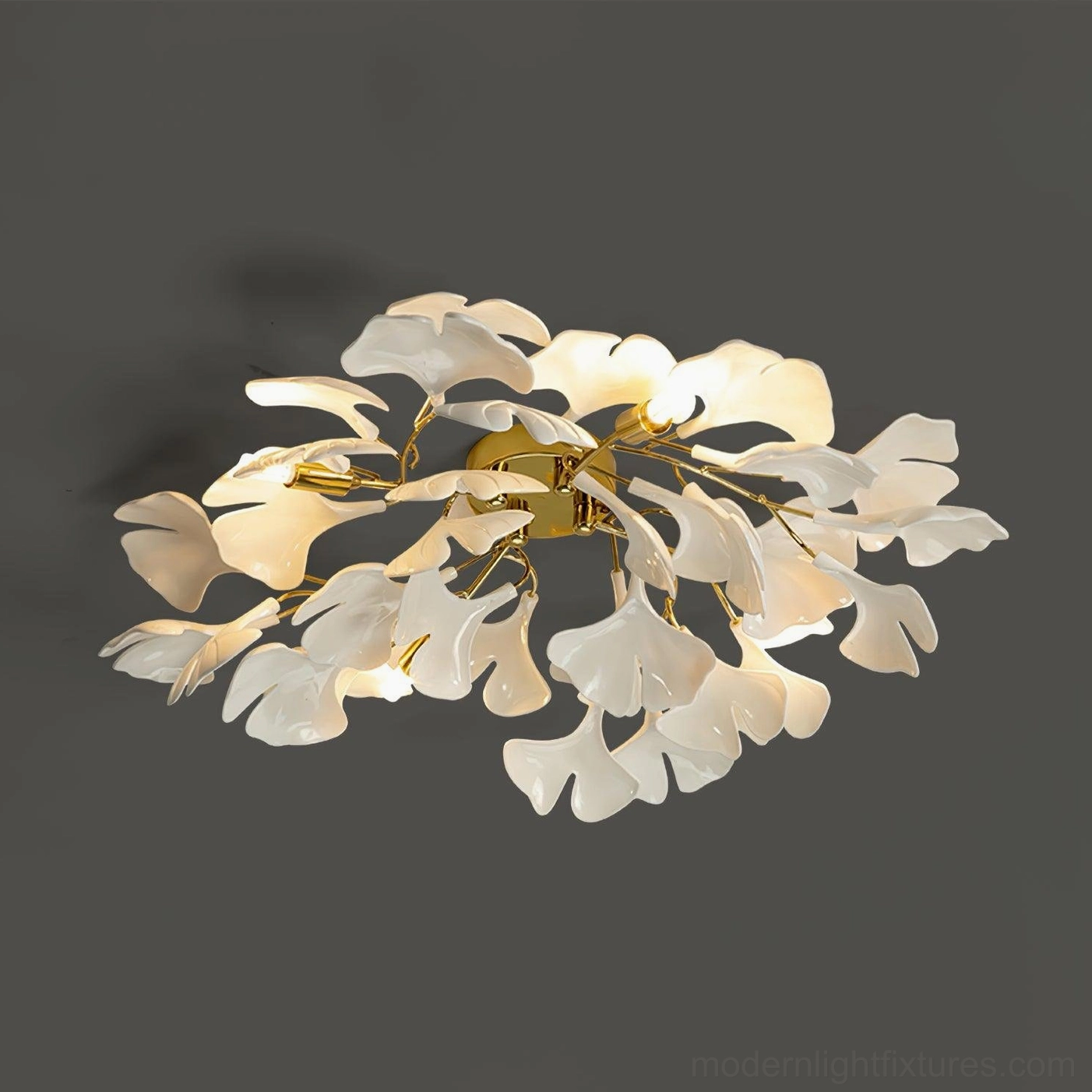 Ginkgo Valla modern ceiling light with gold hardware and white ceramic ginkgo leaf elements, front side close-up on dark background