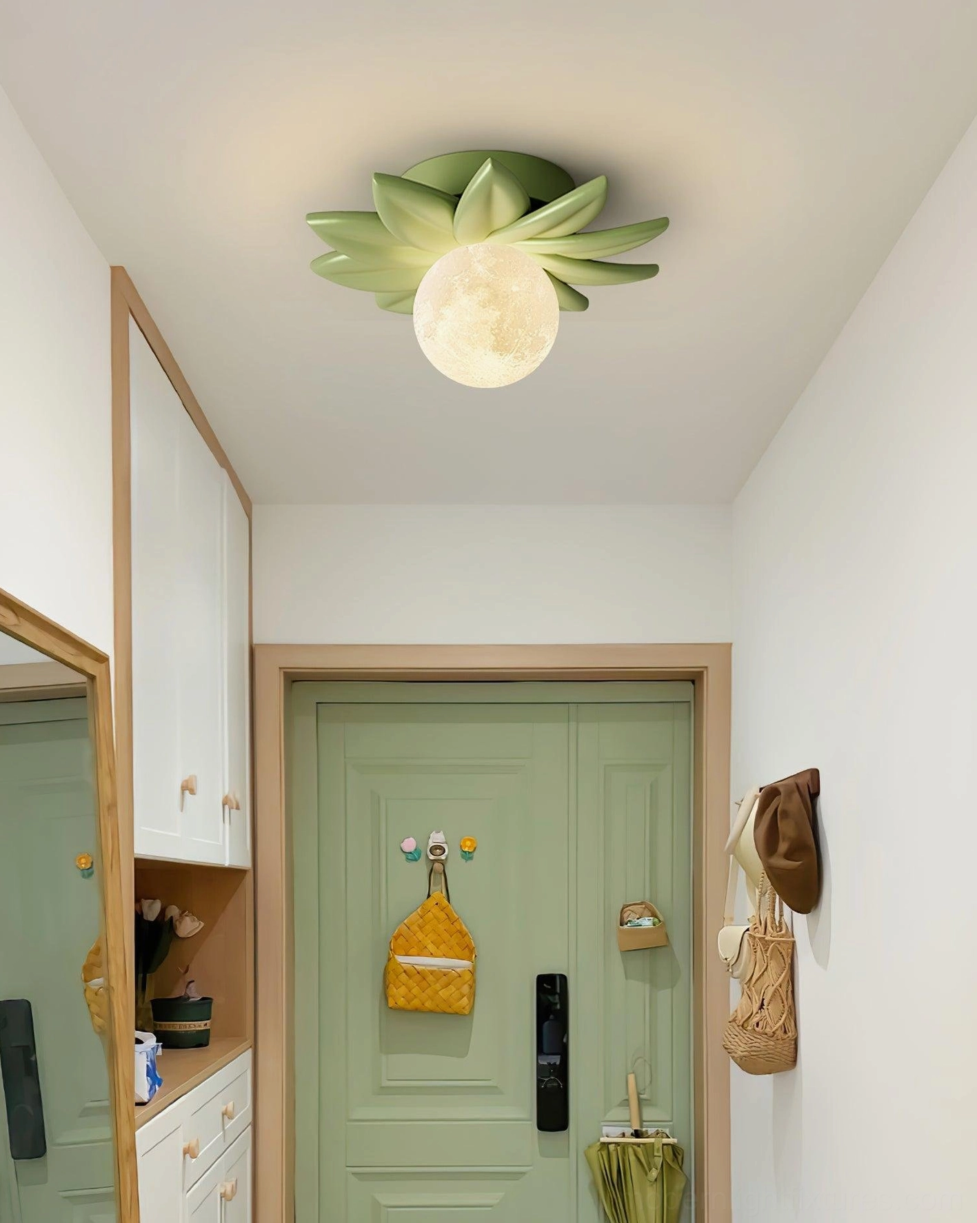 Green Giulia flower ceiling light fixture with fresh warm style installed in residential hallway with green door accent