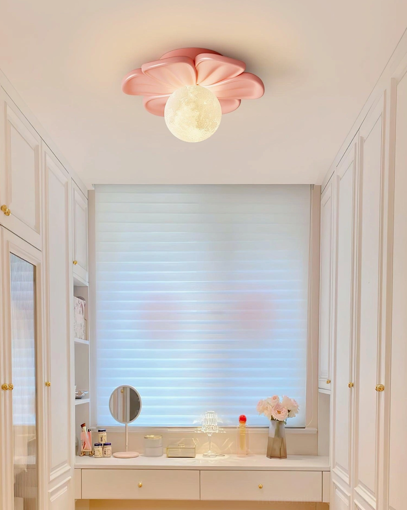 Single pink Giulia flower ceiling light installed overhead in residential vanity room with warm ambient lighting