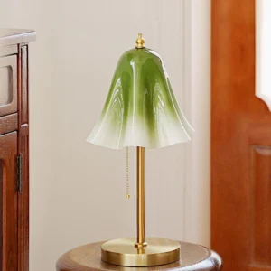 Glacea vintage brass table lamp with ruffled green glass shade and pull chain switch, three-quarter view in home interior setting