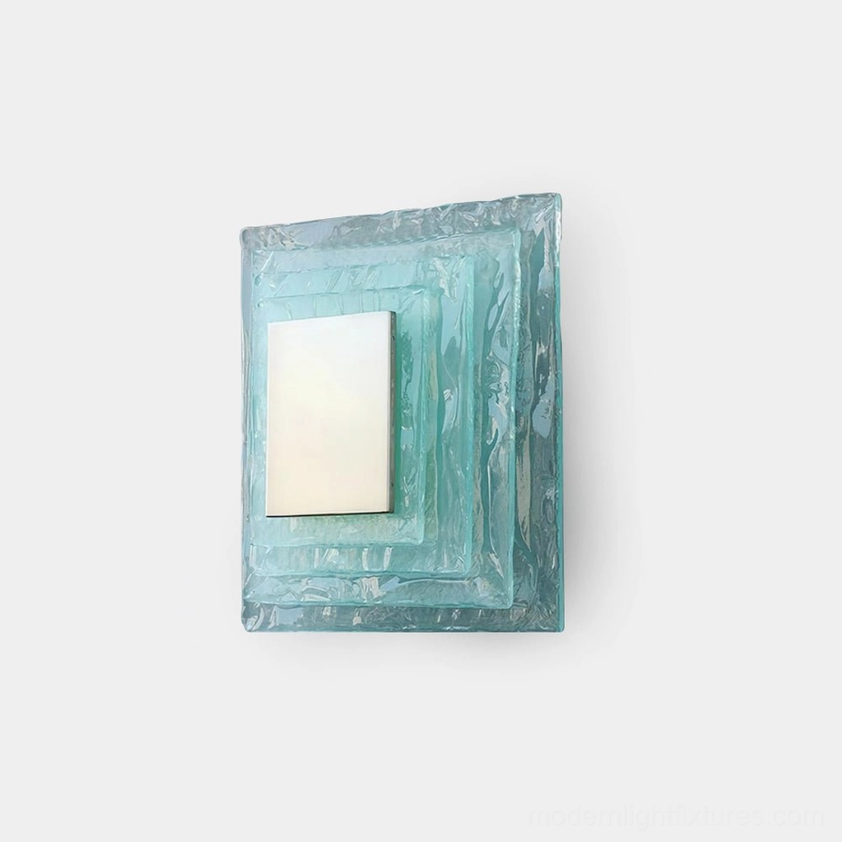 Glacira frosted glass wall sconce front view on white wall, modern layered aqua glass design with warm LED glow