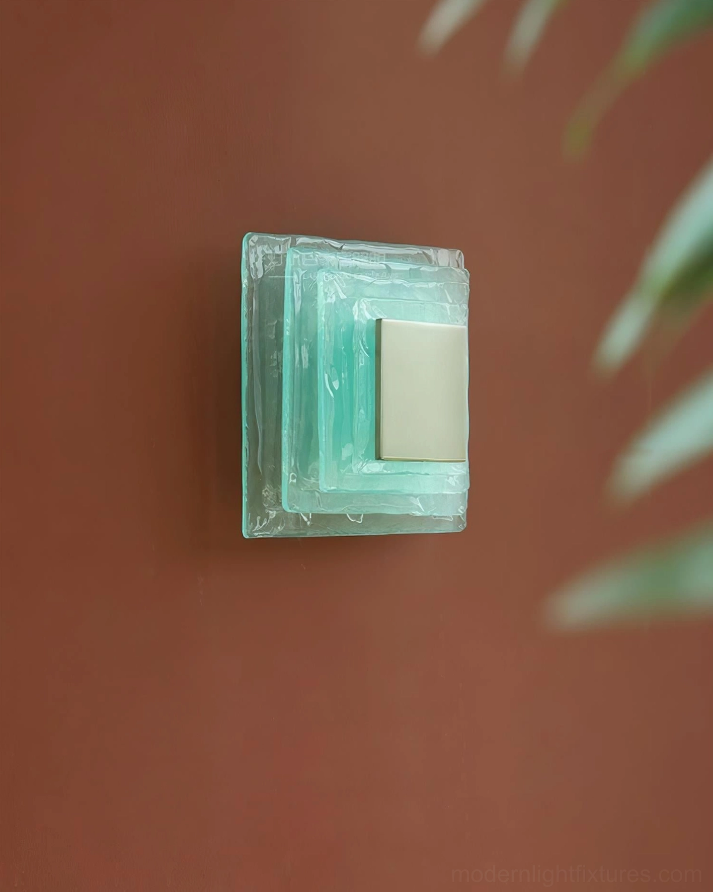 Glacira frosted glass wall sconce oblique angle view on rustic wall with foliage, compact modern lighting design