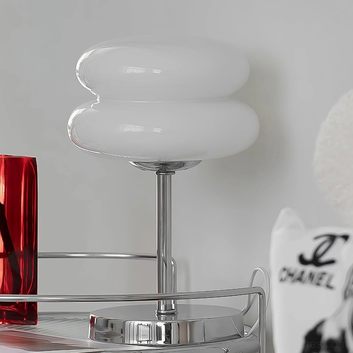 Close-up detail of glossy white glass shade and polished chrome hardware on modern table lamp