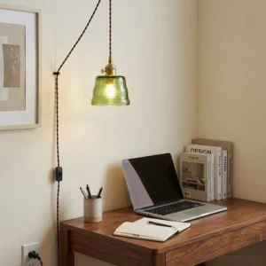 Plug-in glass pendant light installed in warm vintage farmhouse office workspace with brass hardware visible