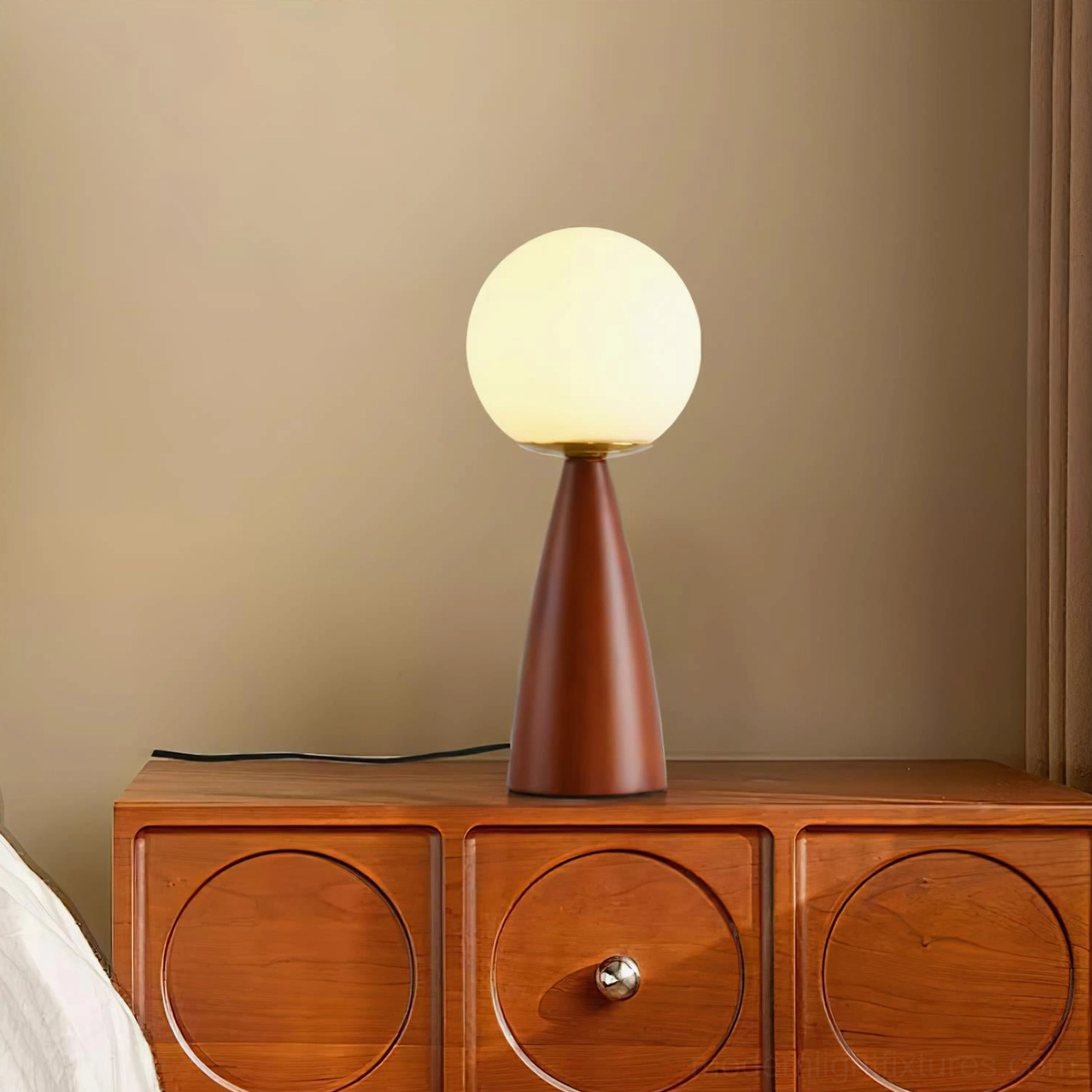 Gleason frosted glass table lamp emitting warm ambient glow on bedroom bedside wooden dresser