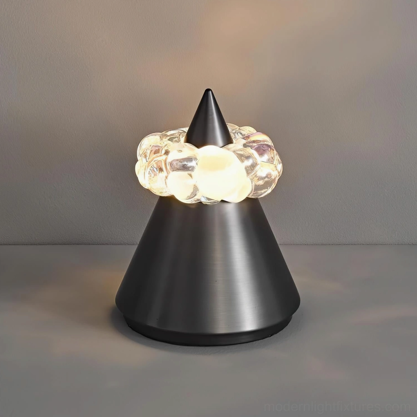 Contemporary accent lighting fixture combining brushed metal cone with jewel-like crystal light ring for bedside or desk use