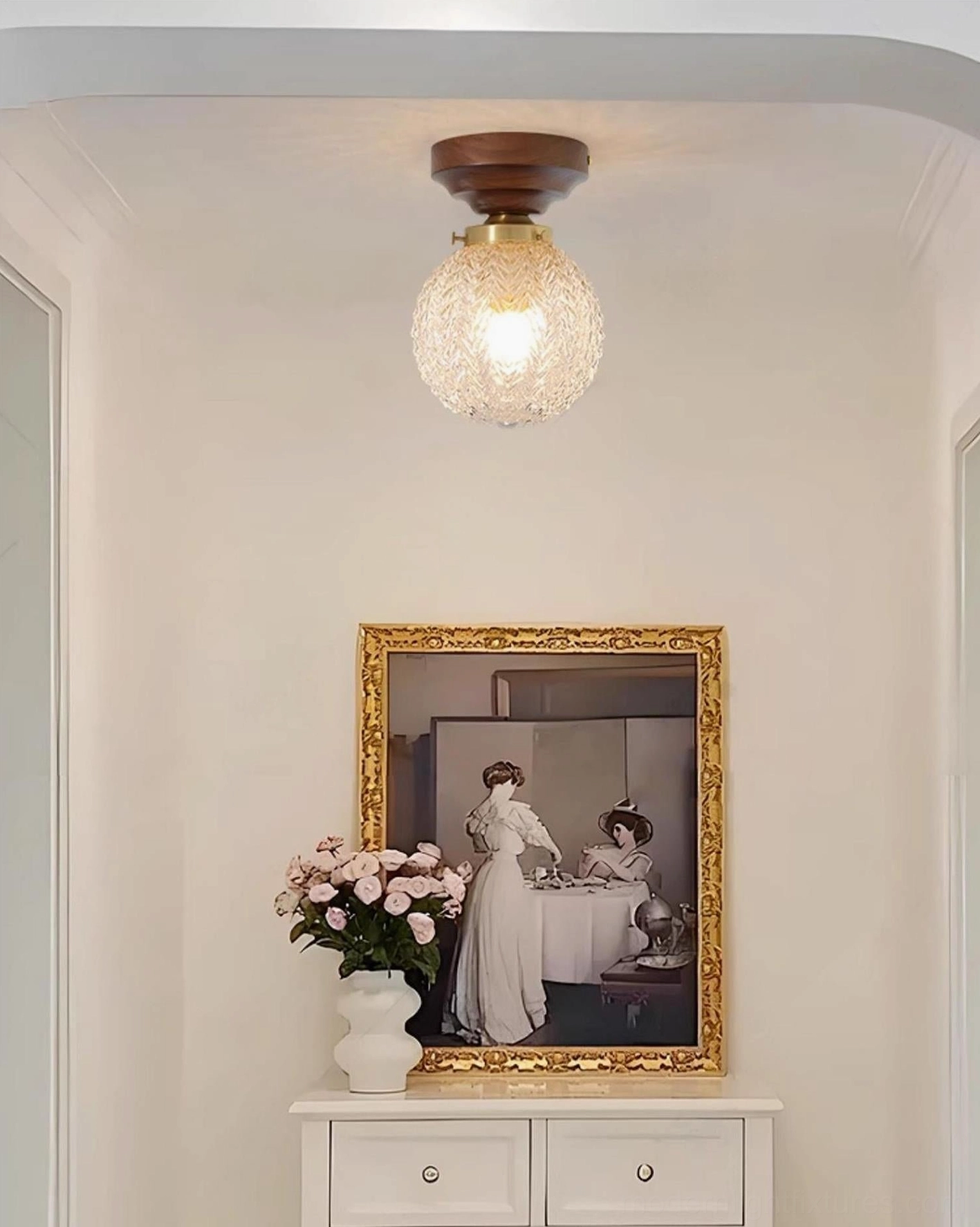 Compact globe ceiling light fixture in vintage entryway above console table, farmhouse modern interior design