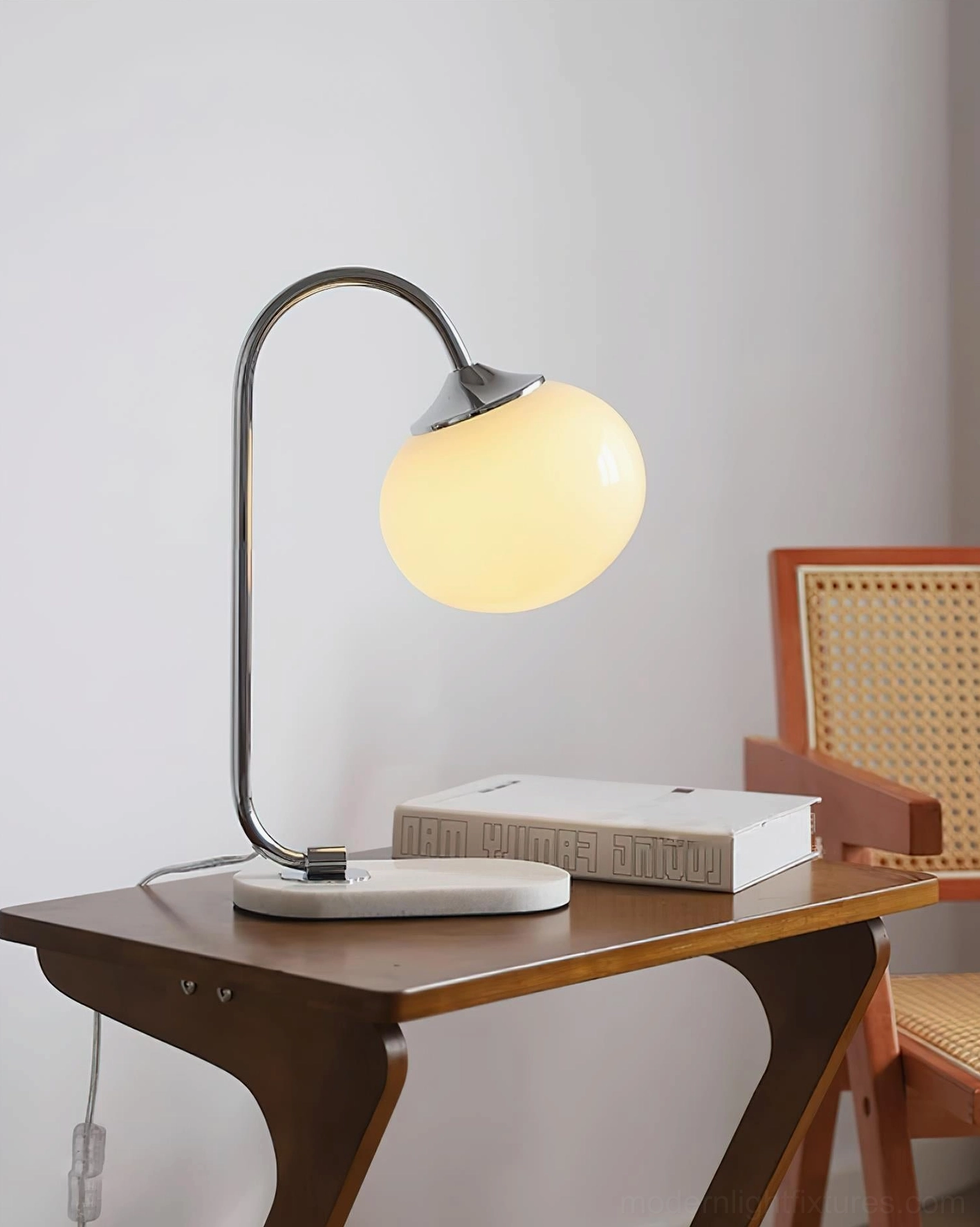 Globe table lamp showing off-white beige glass shade with chrome metal frame construction