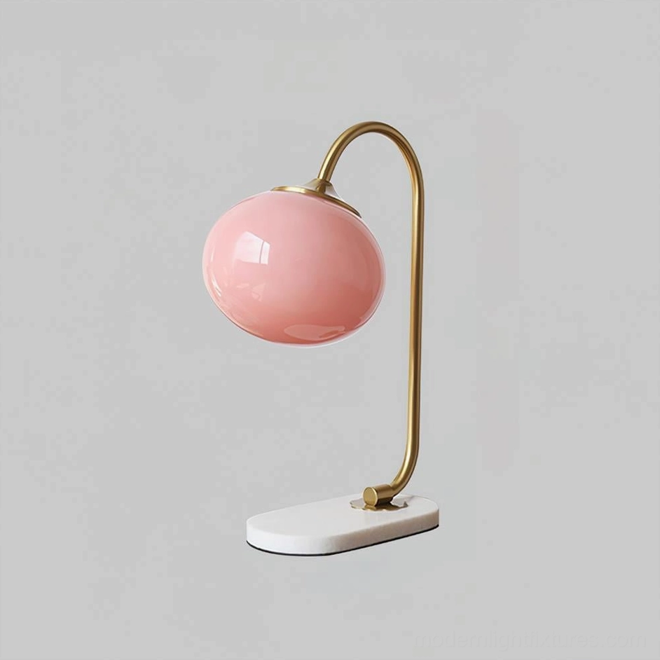 Globe table lamp with clear frosted glass shade and gold metal curved frame detail