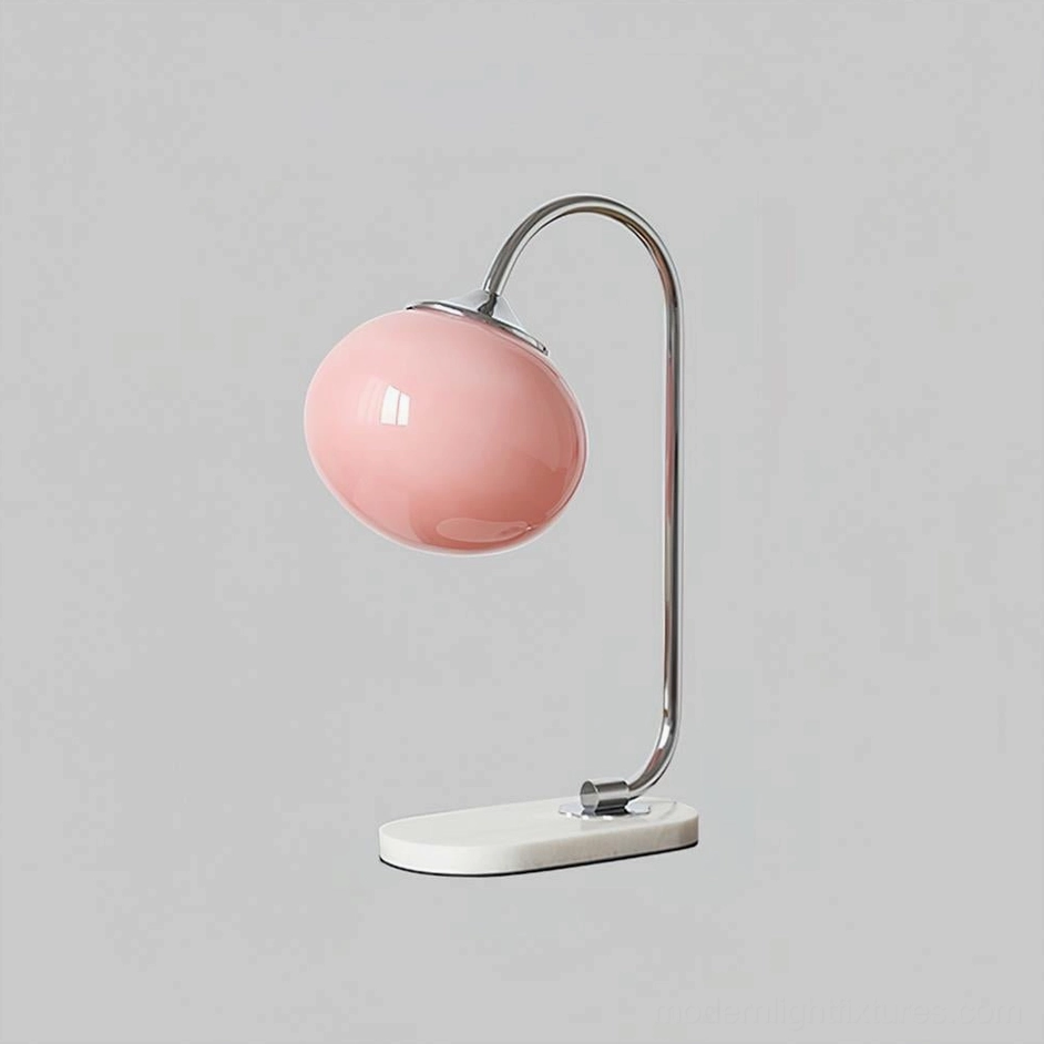 Globe table lamp featuring pink glass shade with chrome silver metal curved frame design