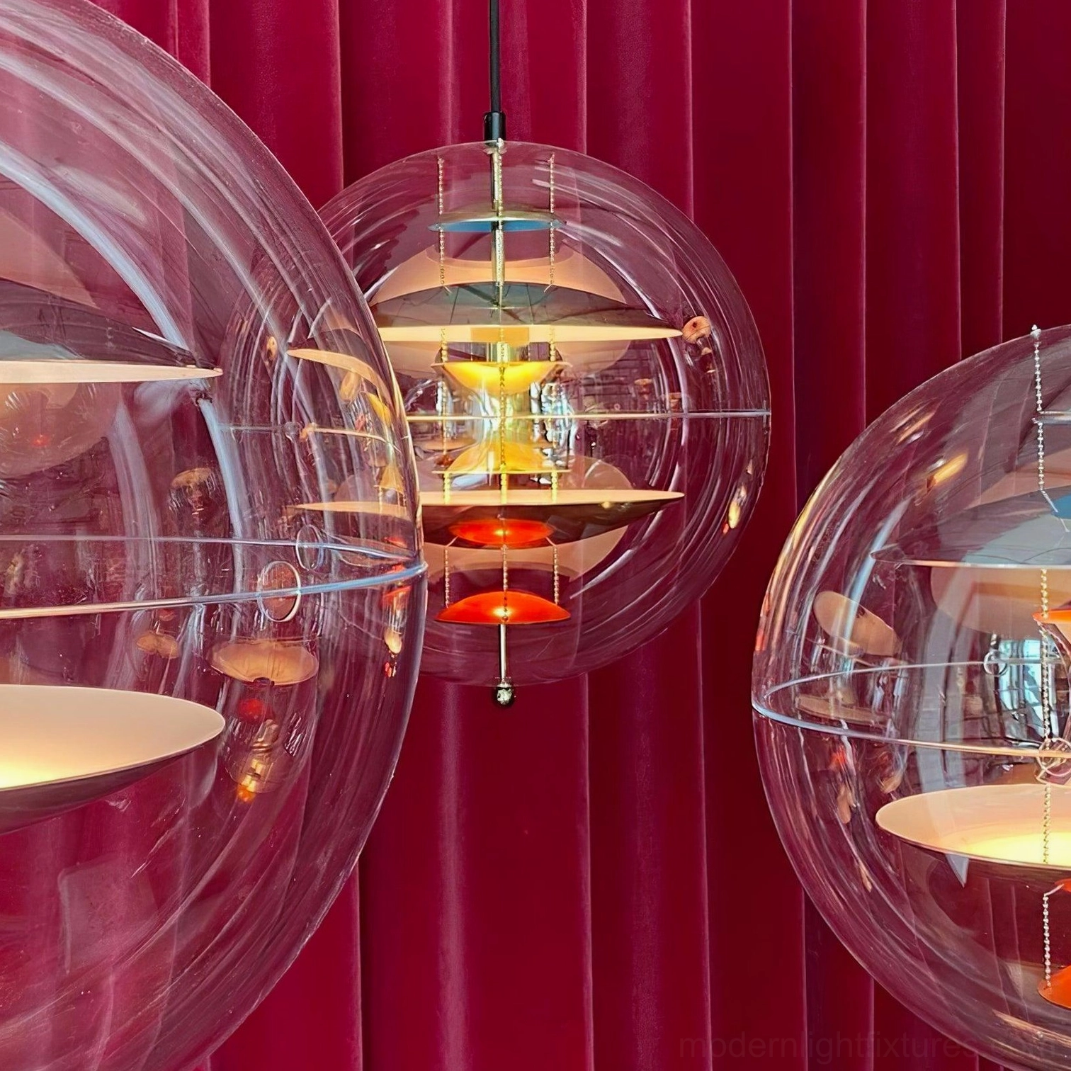 Close-up detail of globe pendant light showing clear acrylic sphere and precision aluminum reflector design