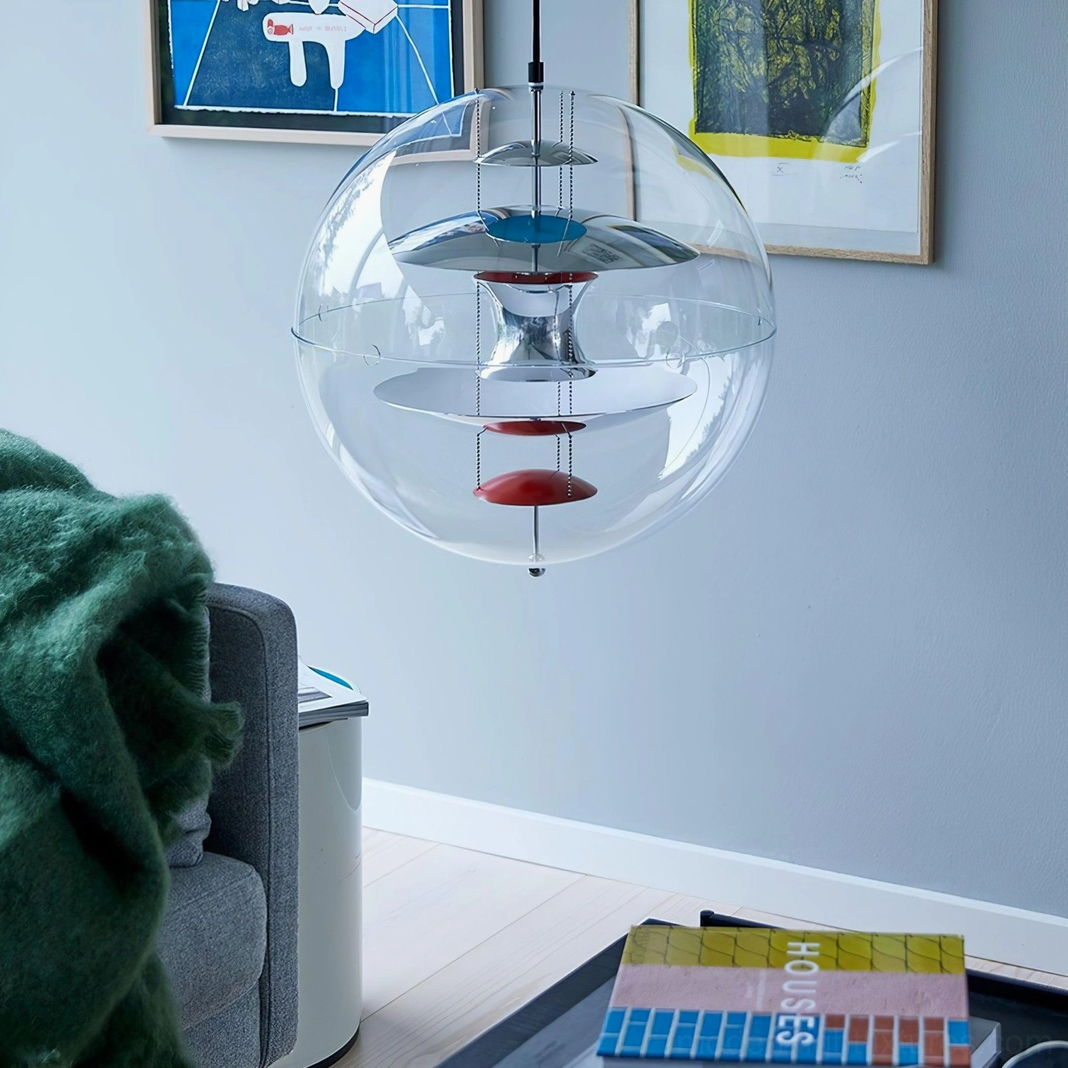 Globe pendant light in contemporary living room with clear acrylic sphere and silver-blue-red layered metal interior