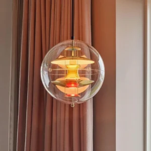 Globe pendant light illuminated showing warm glow through clear acrylic shade with multi-layered aluminum interior structure