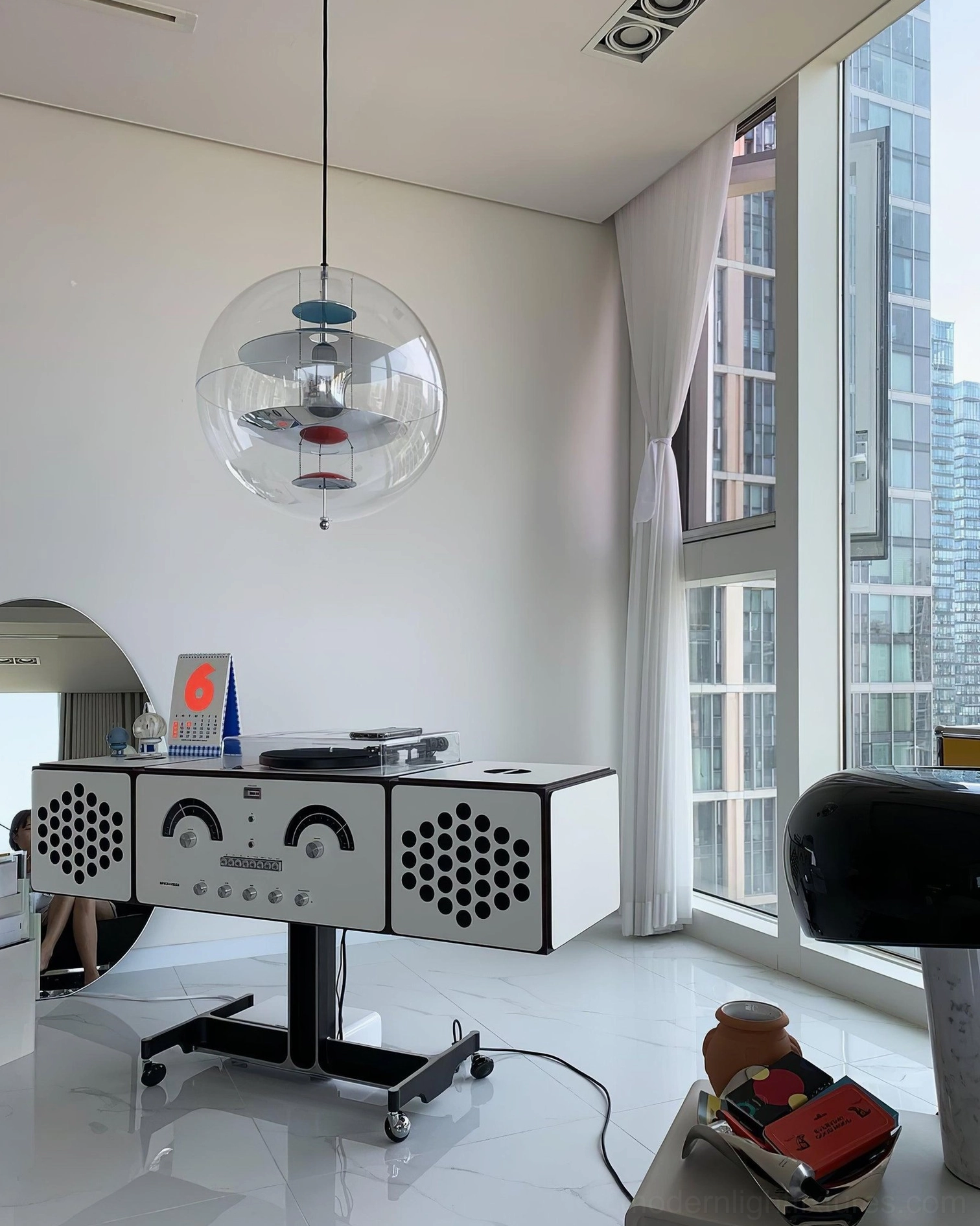 Globe pendant light in high-floor modern apartment with blue-red inner structure, city view windows and minimalist furniture