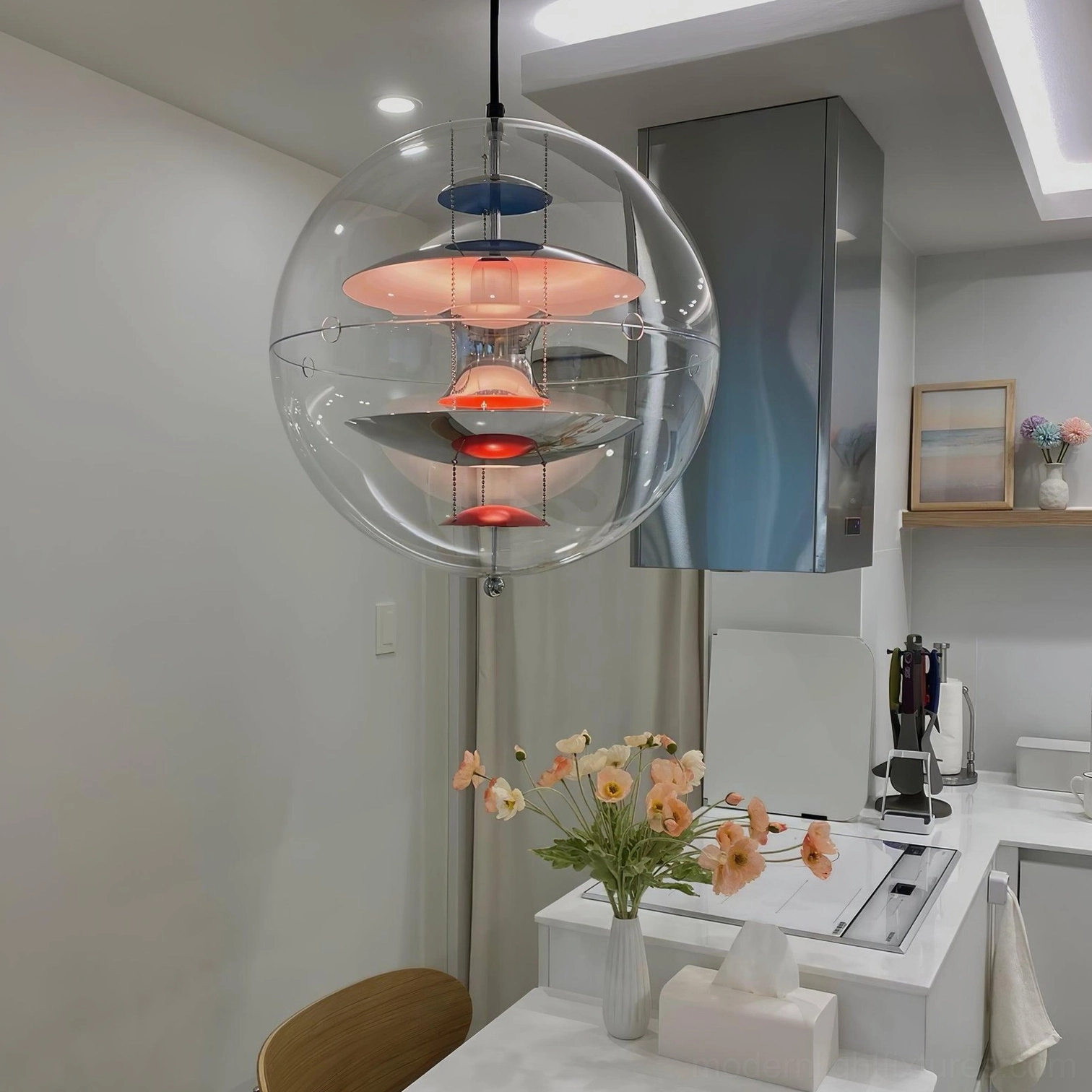 Globe pendant light in contemporary kitchen with pink-blue-red layered interior design and clear acrylic shade near range hood