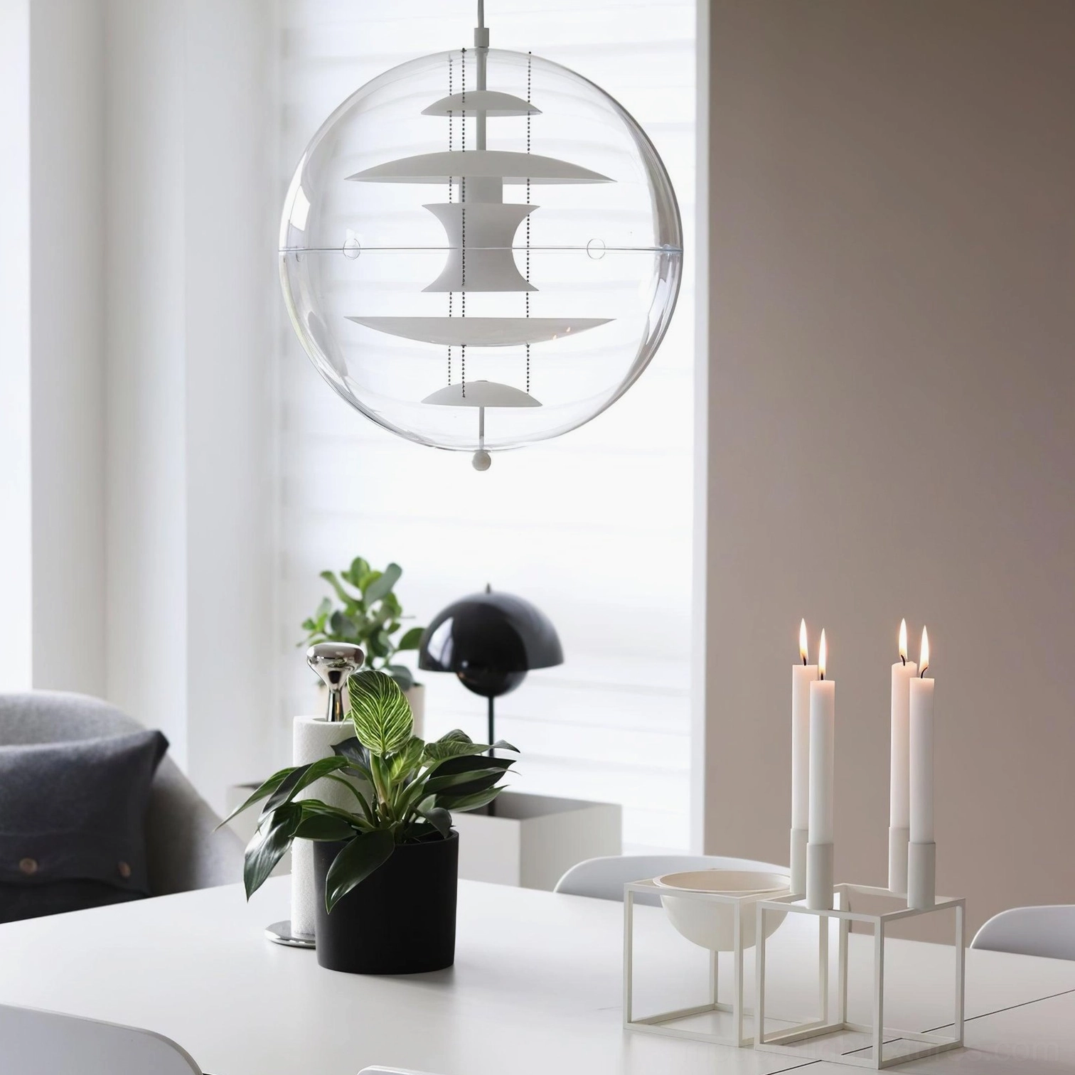 Modern spherical pendant light showcasing geometric design and transparent material composition from side angle