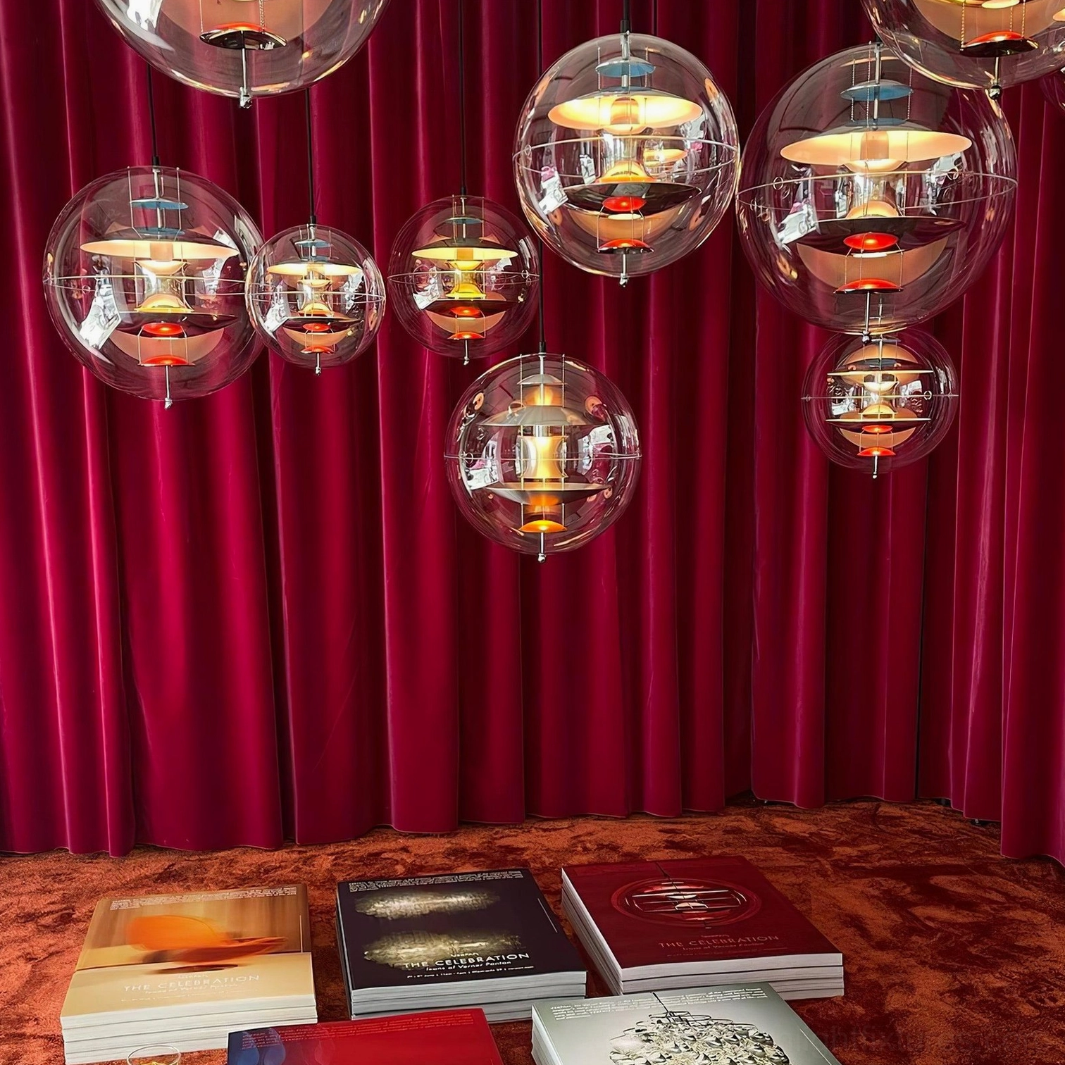 Illuminated globe pendant showing warm light emission through transparent acrylic shade