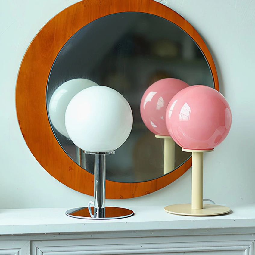 Pair of modern globe table lamps with chrome and beige bases and white pink shades near vanity mirror
