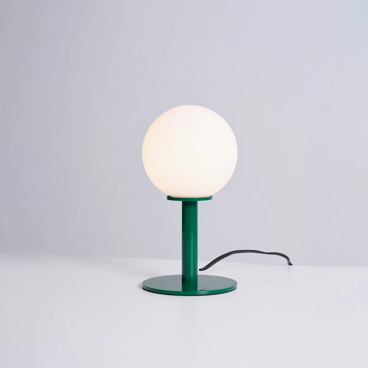 Sleek globe table lamp minimalist aesthetic white glass shade metal base sculptural accent