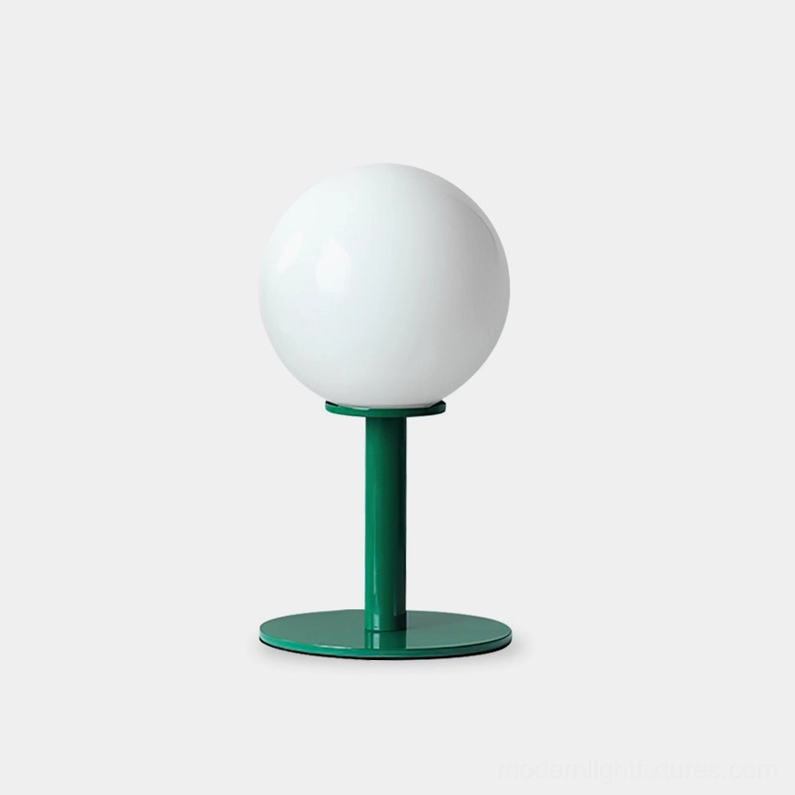 Modern globe table lamp with white glass shade and dark green metal base on white background