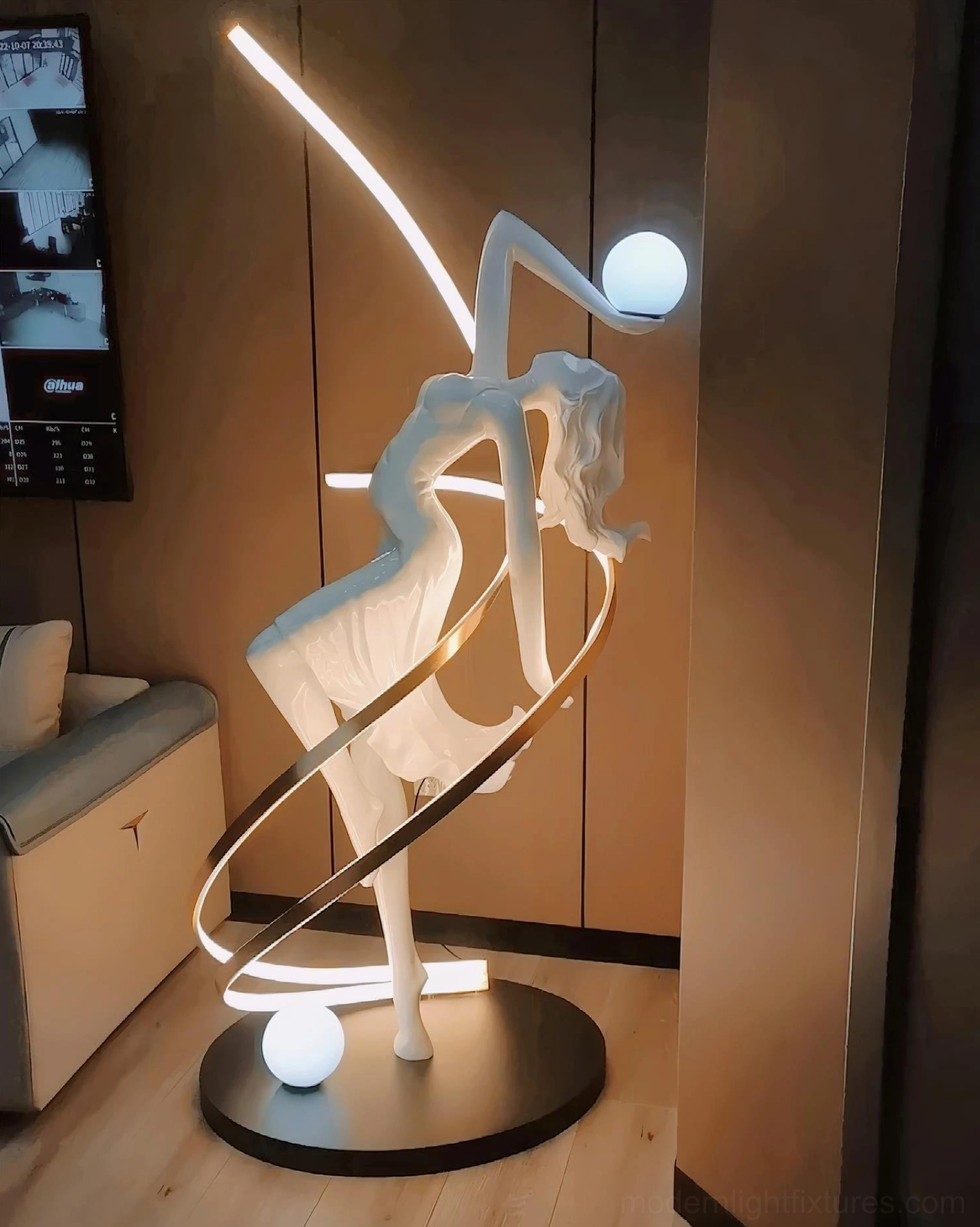 Goddess statue floor lamp illuminated at night creating dramatic shadow effects on wall and floor