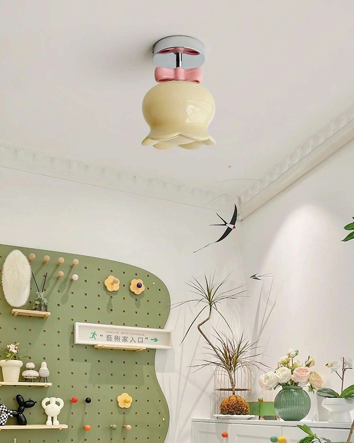 Bell ceiling light fixture with gold metal finish and beige glass shade showing warm illumination and sculptural bell silhouette