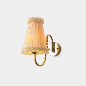 Gold brass pleated wall sconce with beige fabric shade front three-quarter view