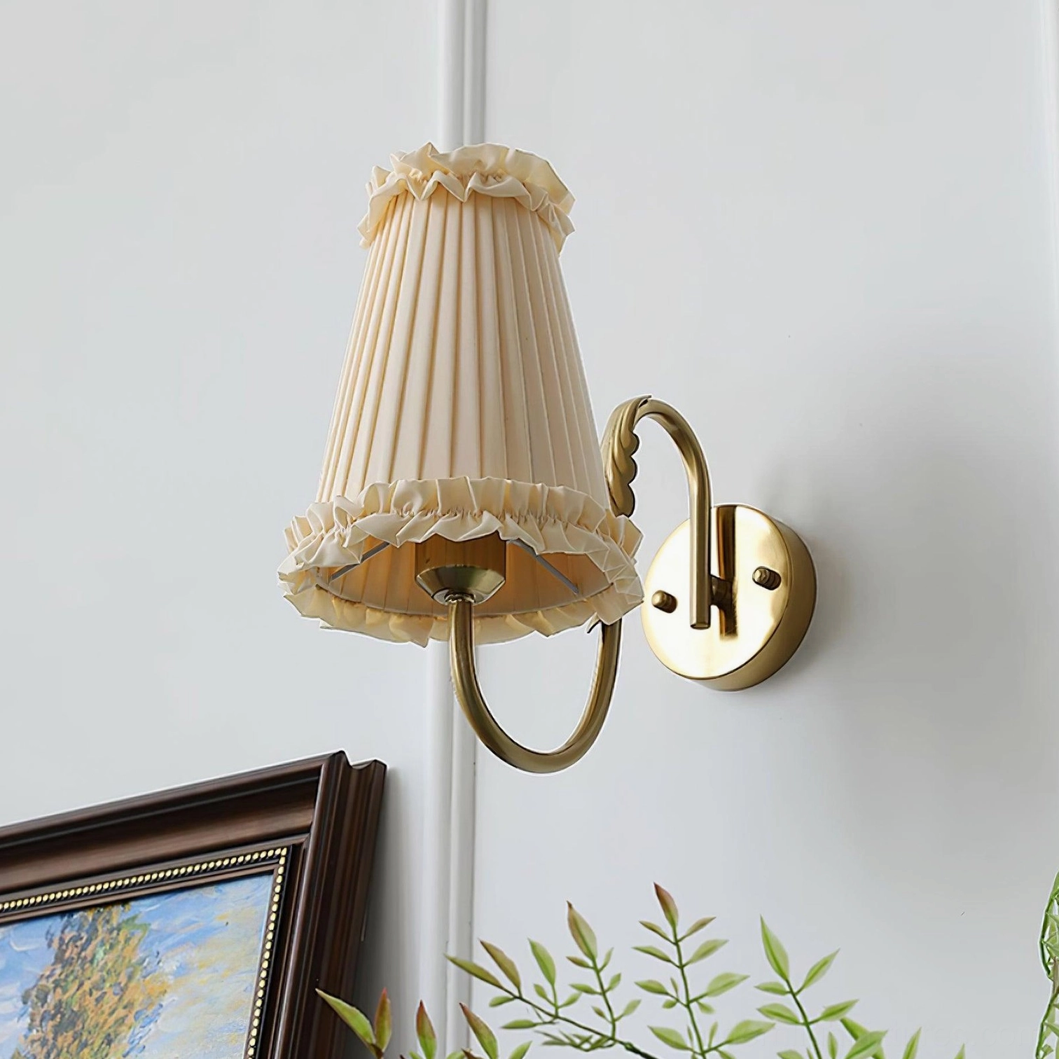 Gold brass wall sconce with pleated beige fabric shade front angle display